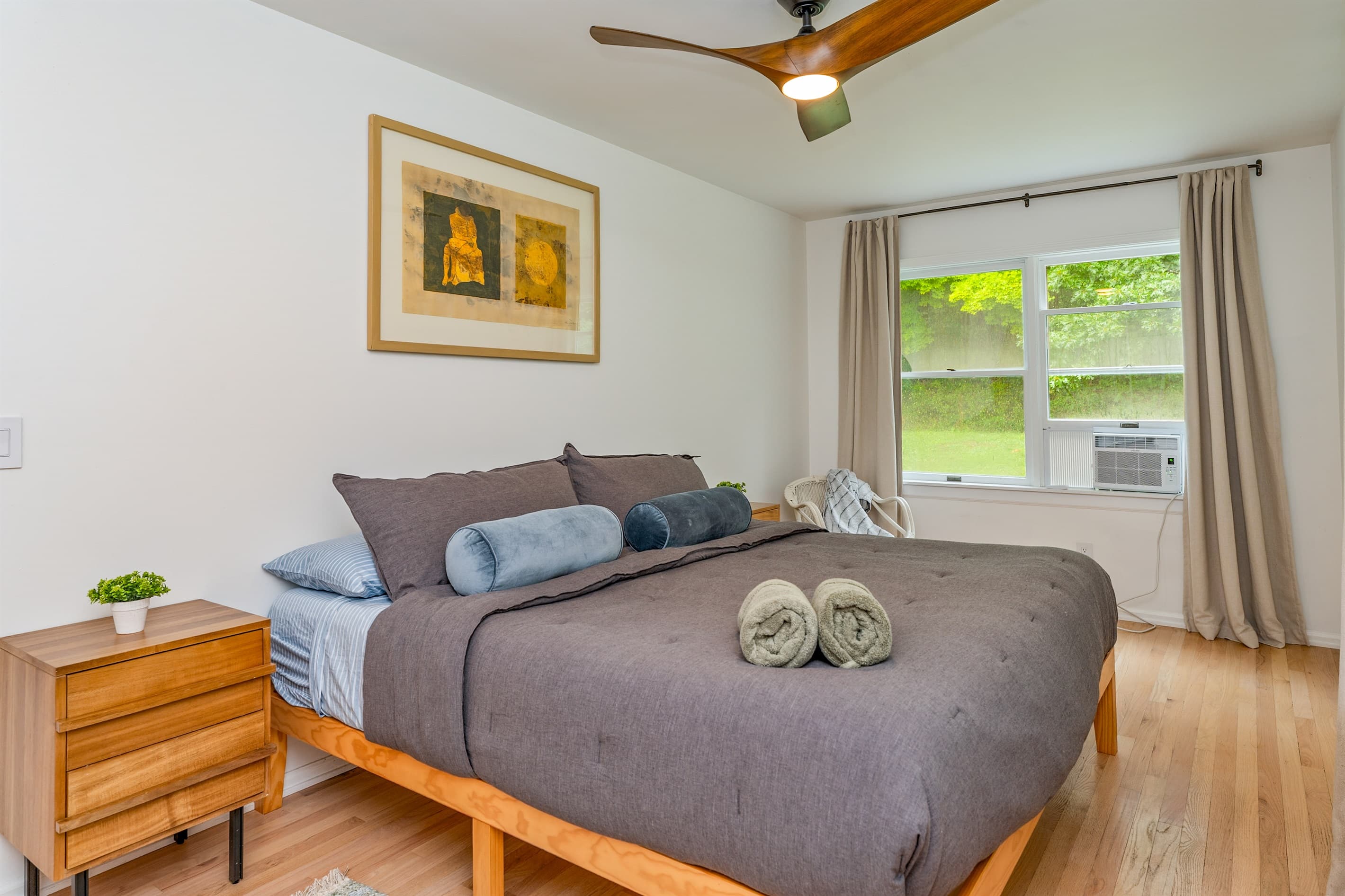 Bedroom with gray bedding and ceiling fan