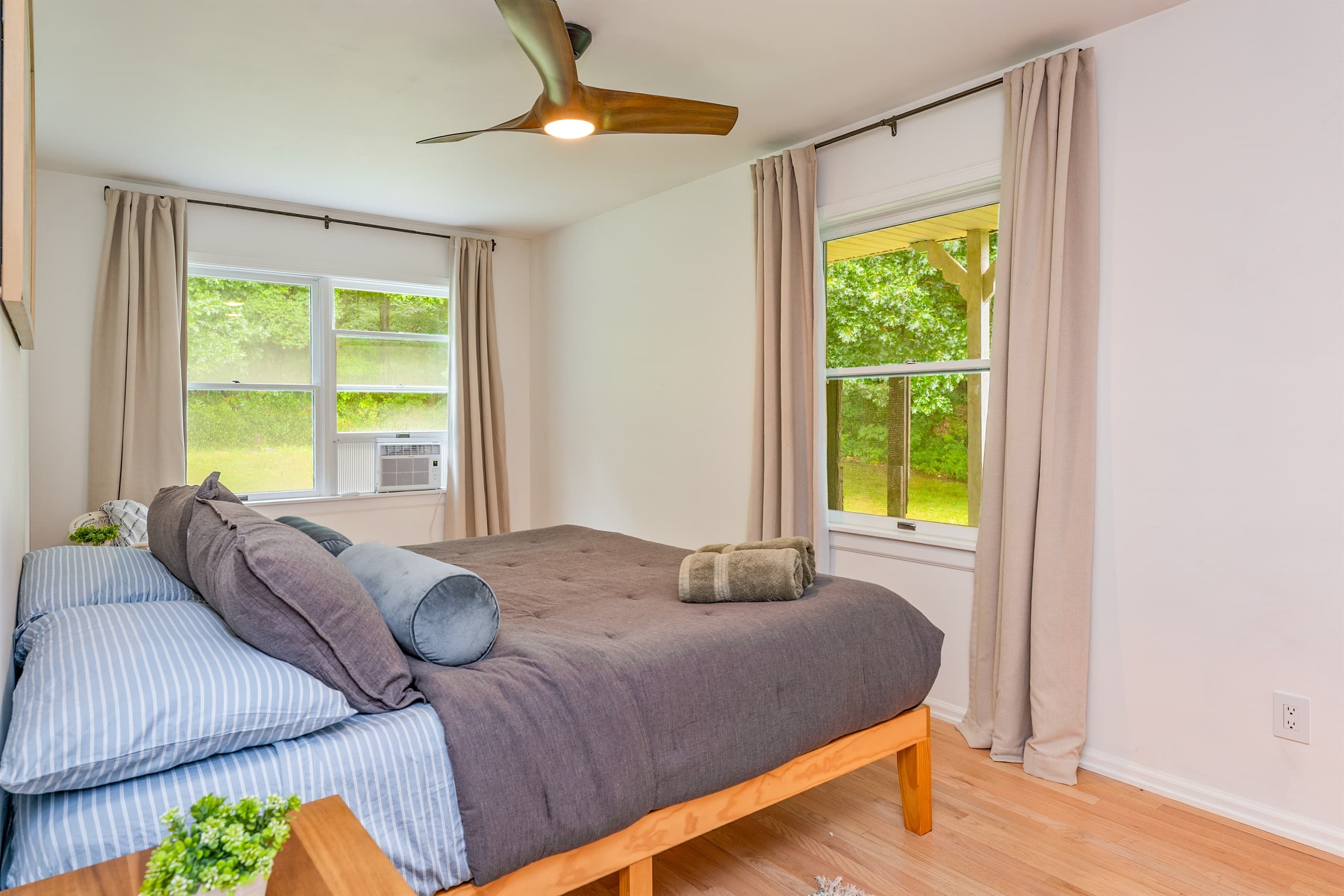 Bedroom with large windows and ceiling fan