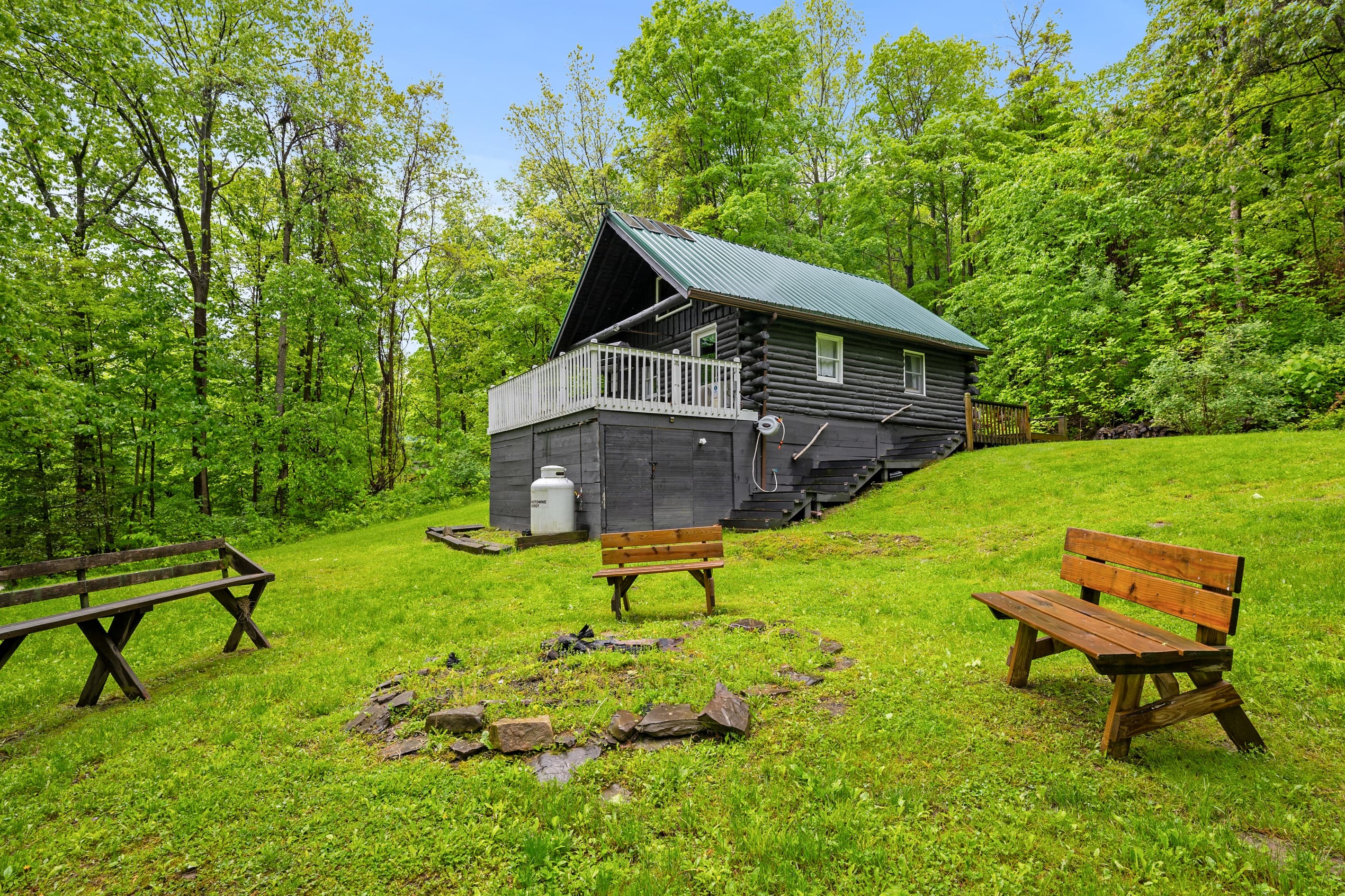 Log cabin exterior with stone fire pit