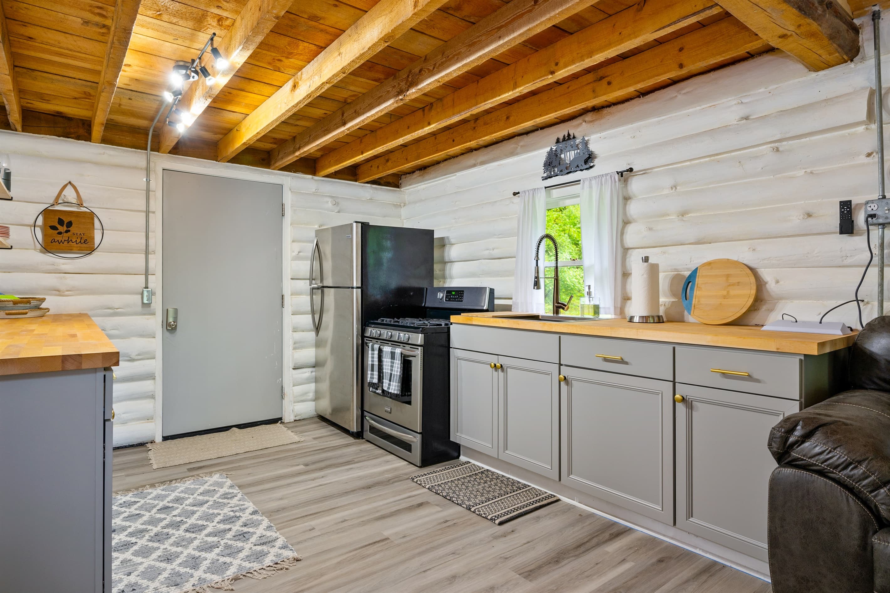 Kitchen with white log wall and wood countertops
