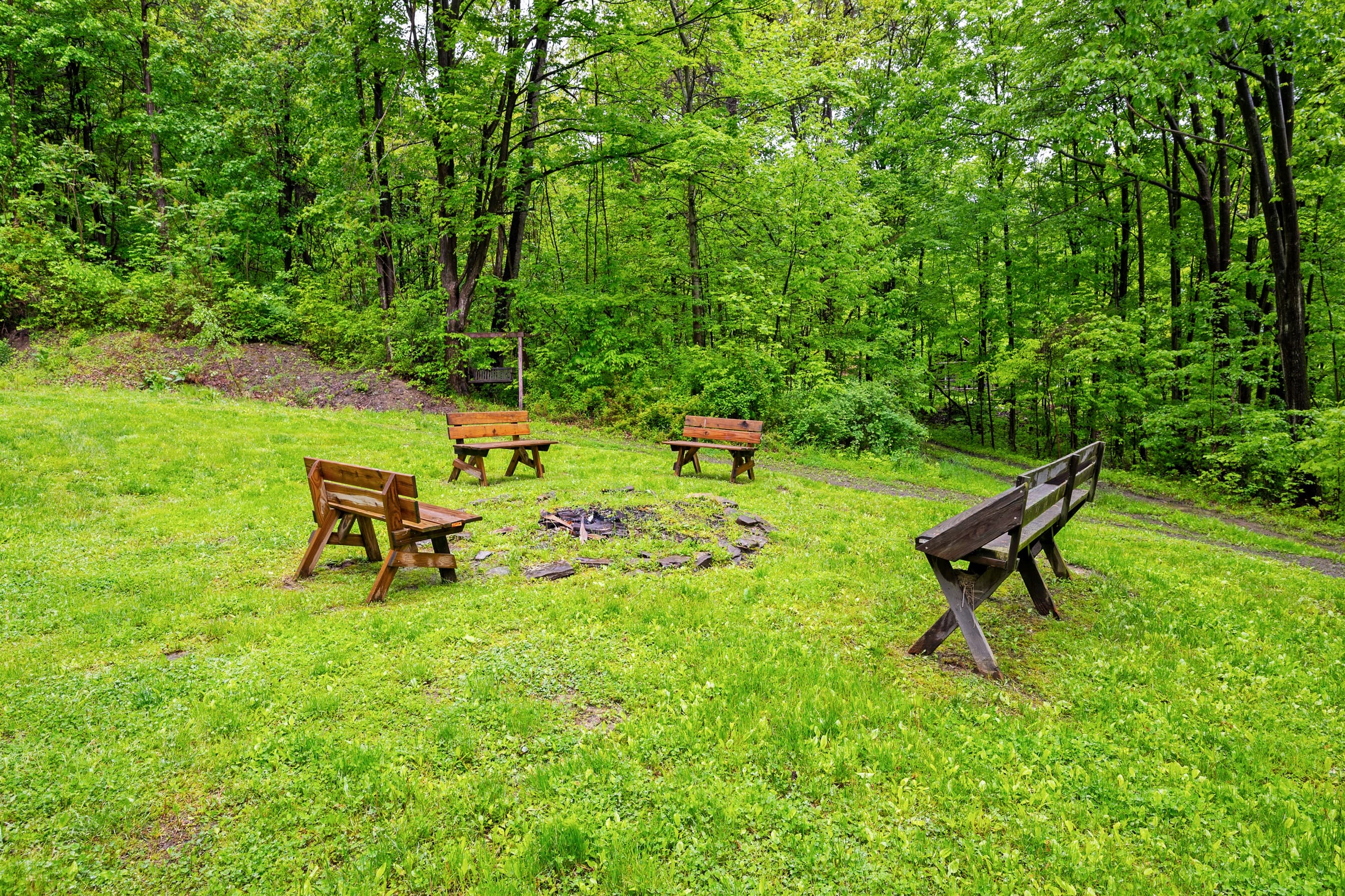 Fire pit area surrounded by wooden benches 