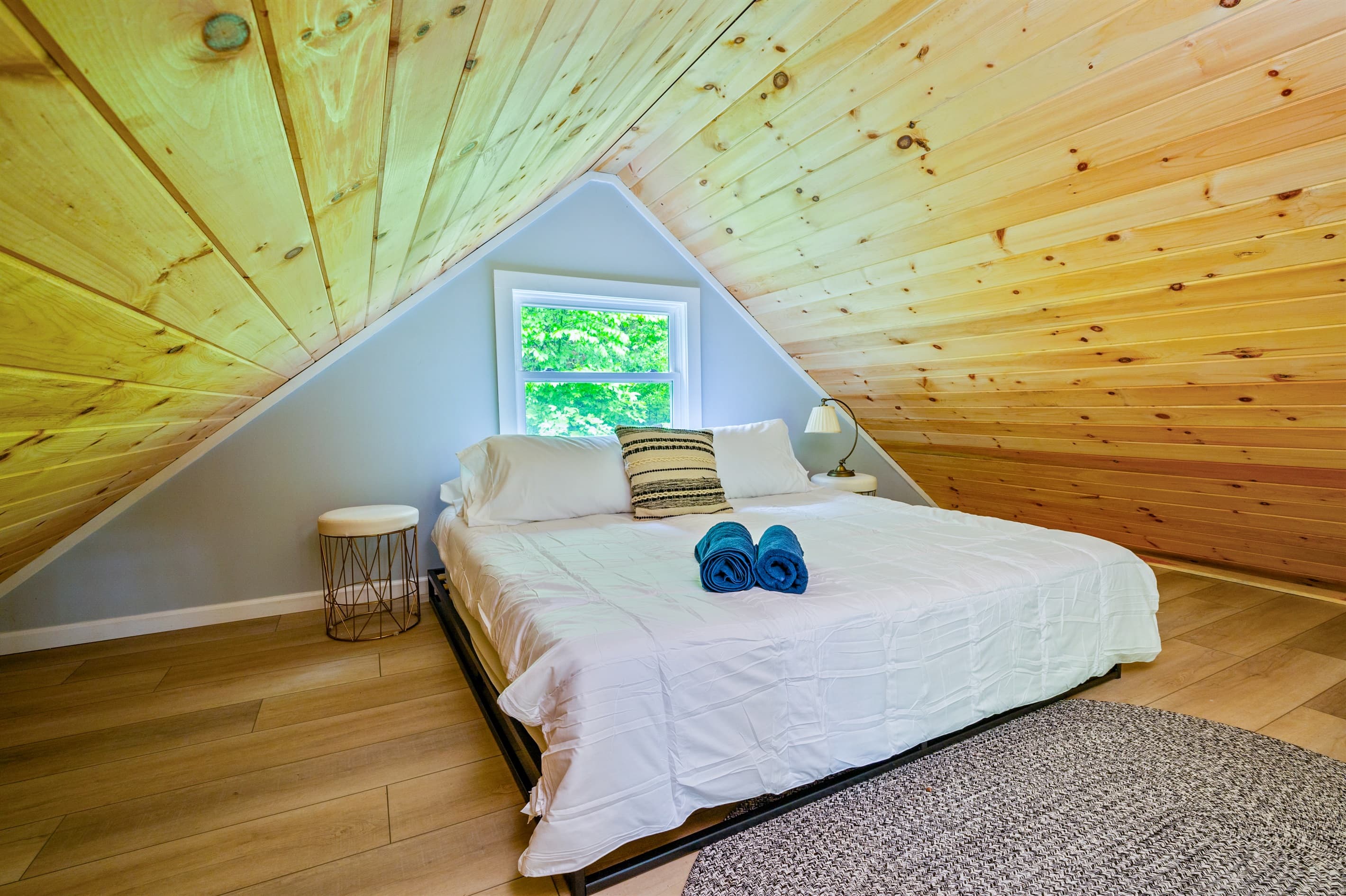 Loft bedroom beneath sloped wood ceilings