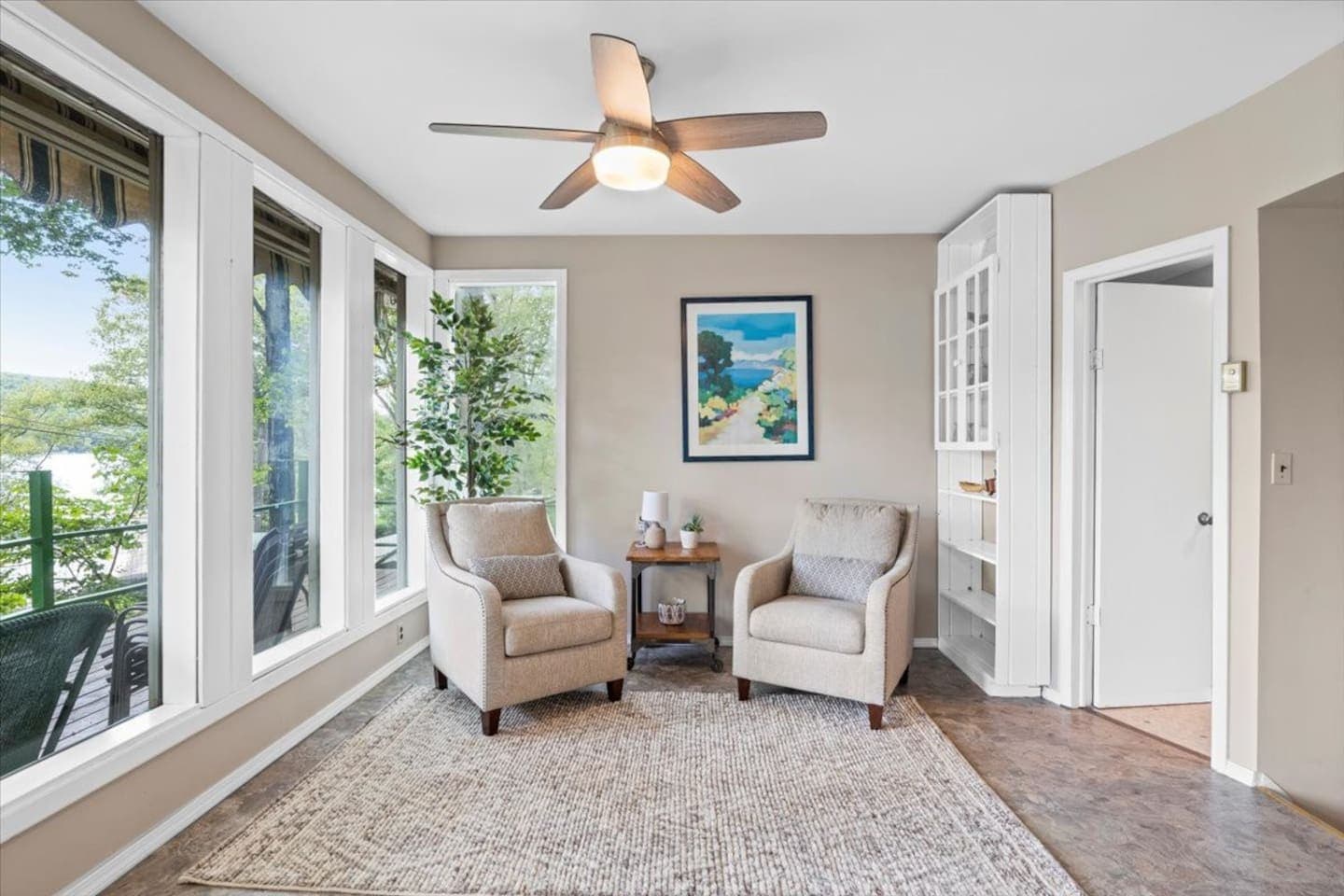 Two armchairs centered by a wooden side table 