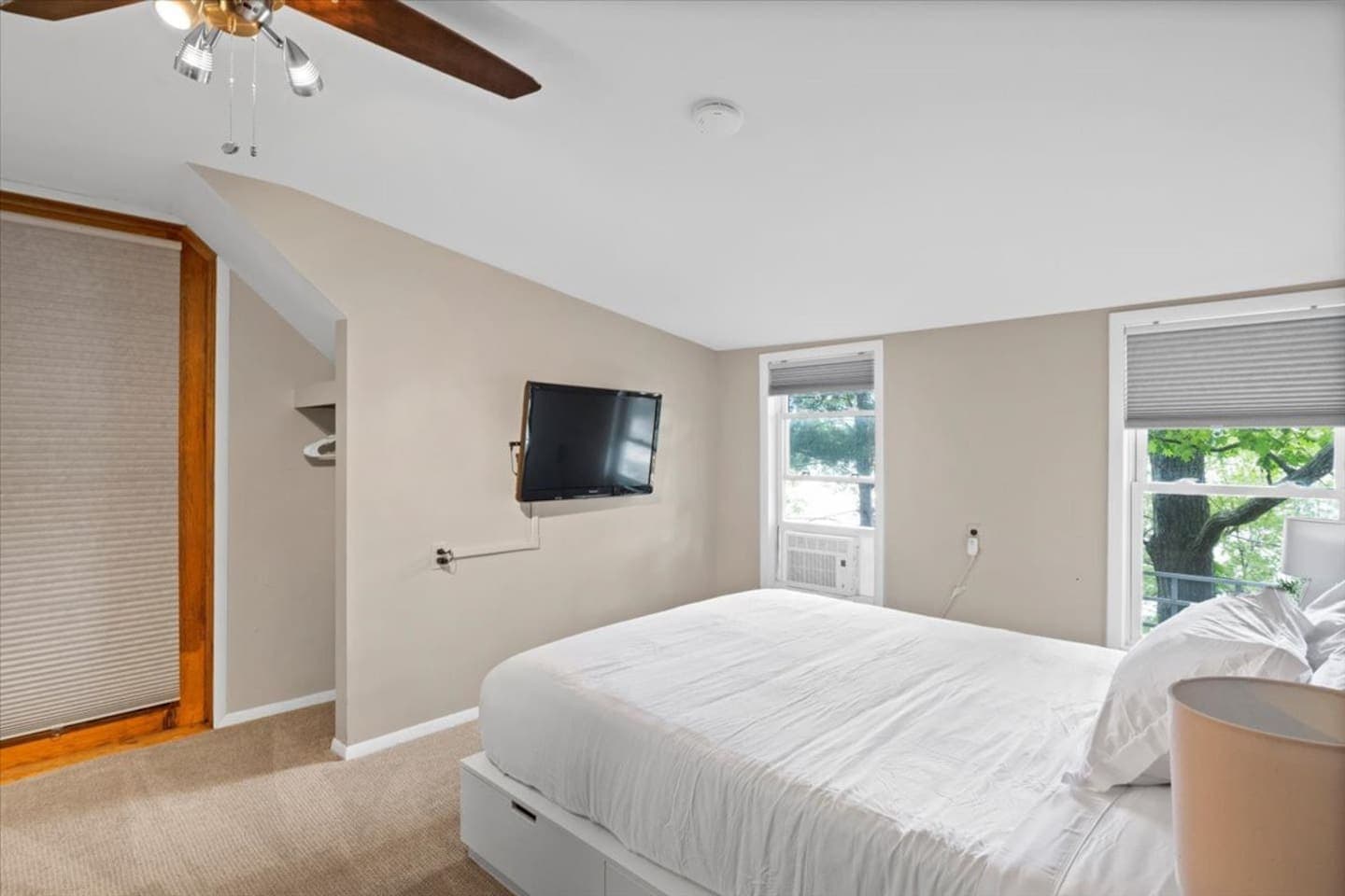 Wall-mounted television opposite the bed