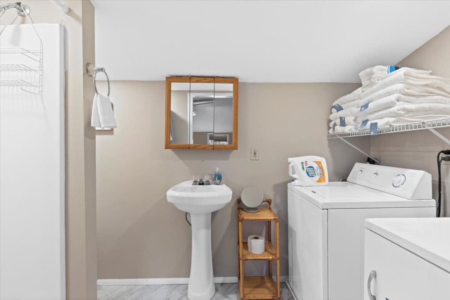 Washer and dryer beside pedestal sink