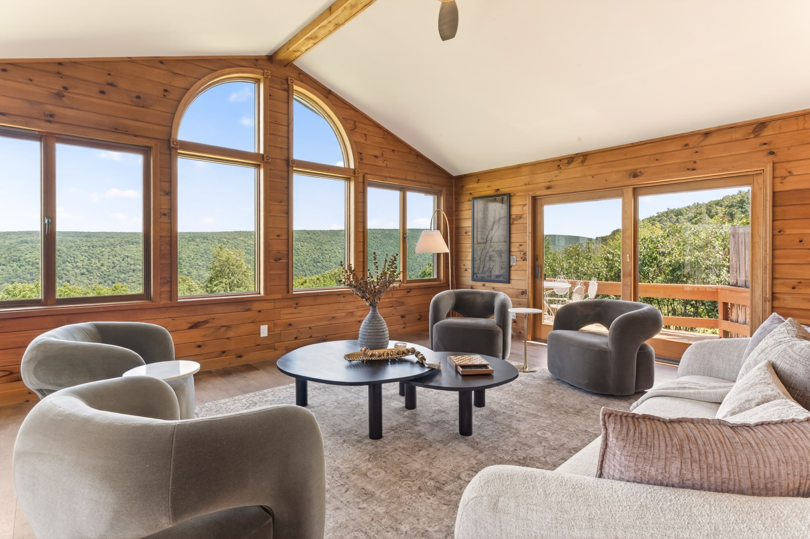 Window-lined sunroom with multiple seating areas