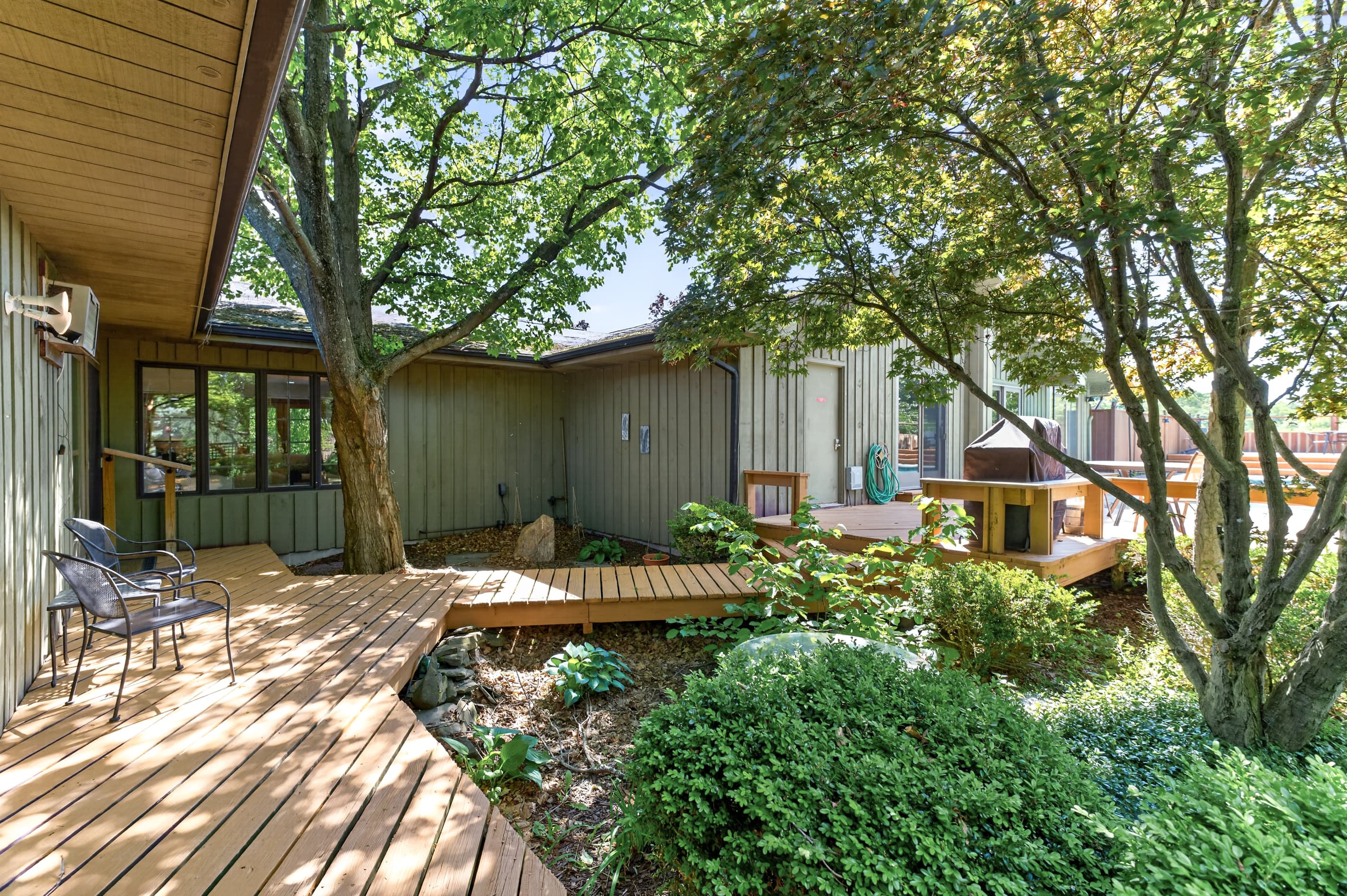Shaded wooden walkway through the landscaped yard
