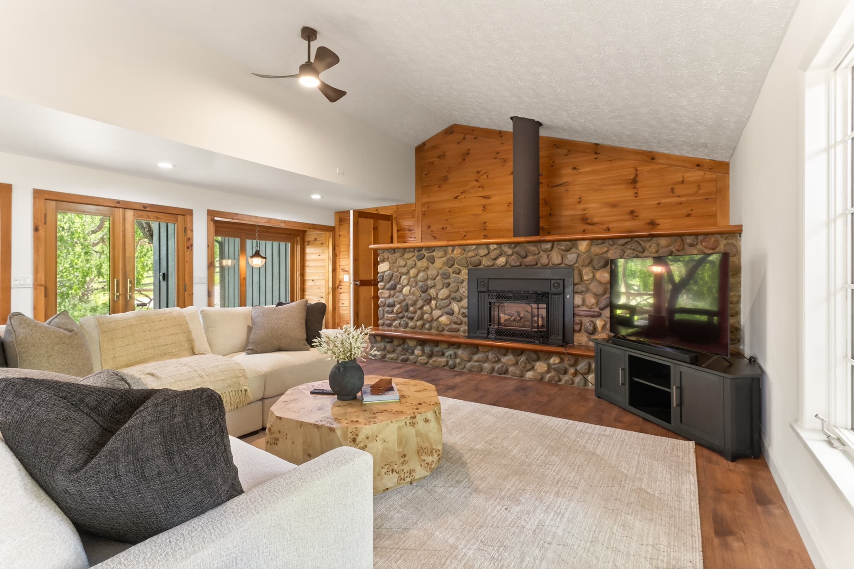 Living room with stone fireplace and television