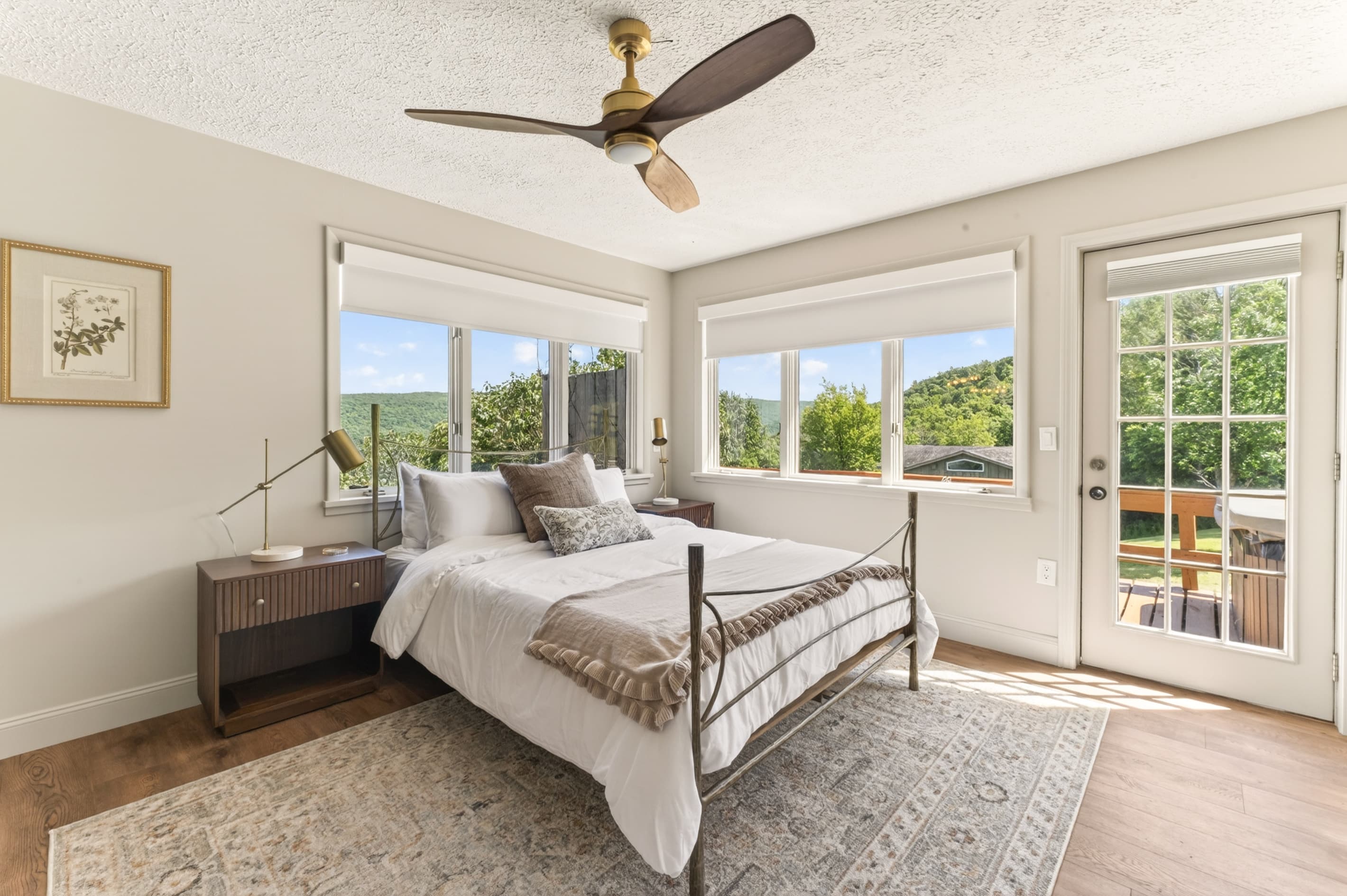 Sunroom with a bed seating beneath a ceiling fan