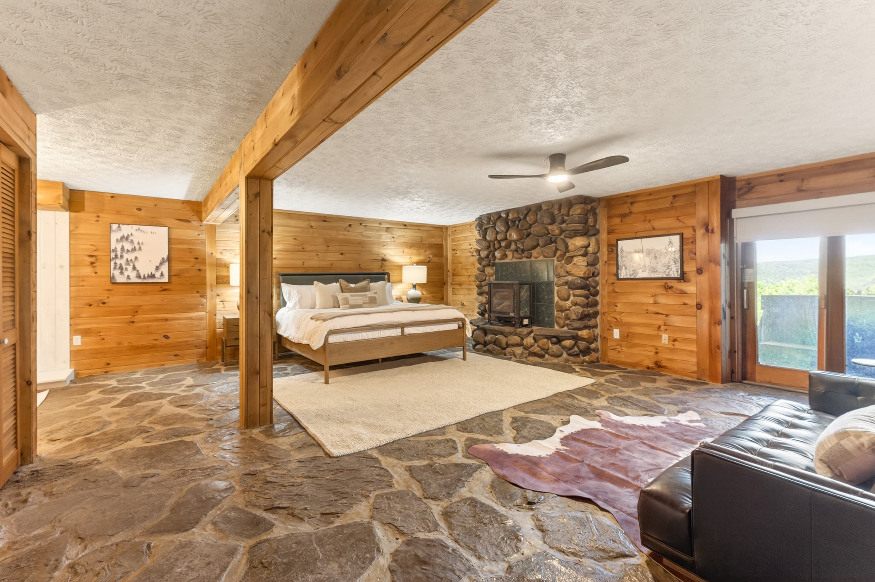 Bedroom with exposed beams and stone fireplace