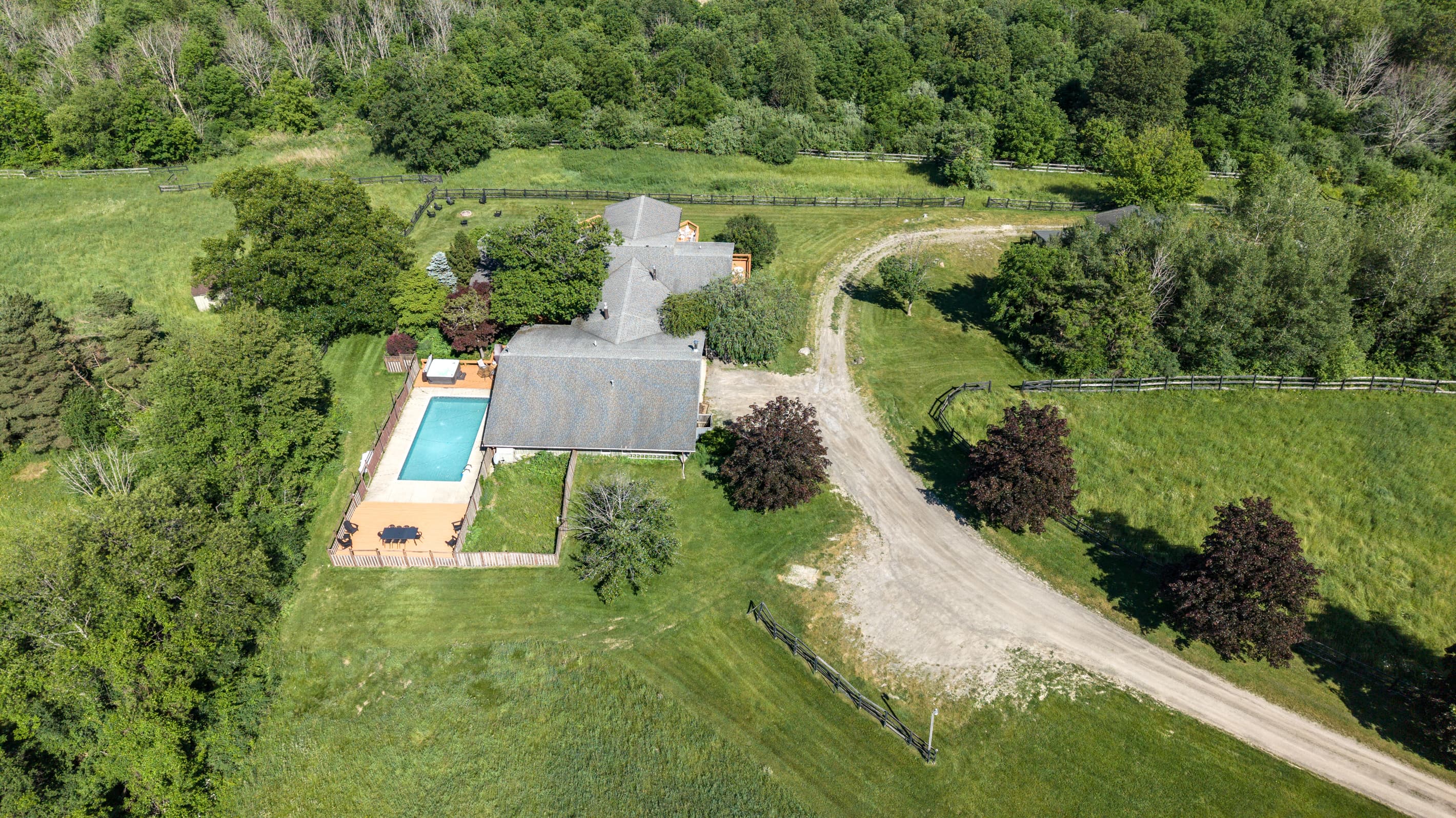 Aerial view highlighting the pool and driveway