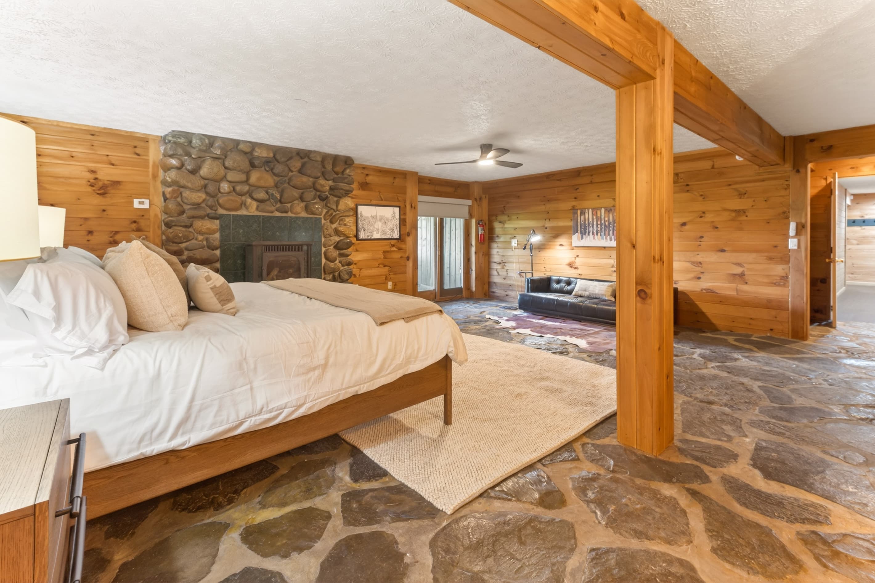 Bedroom with stone fireplace and wood beams