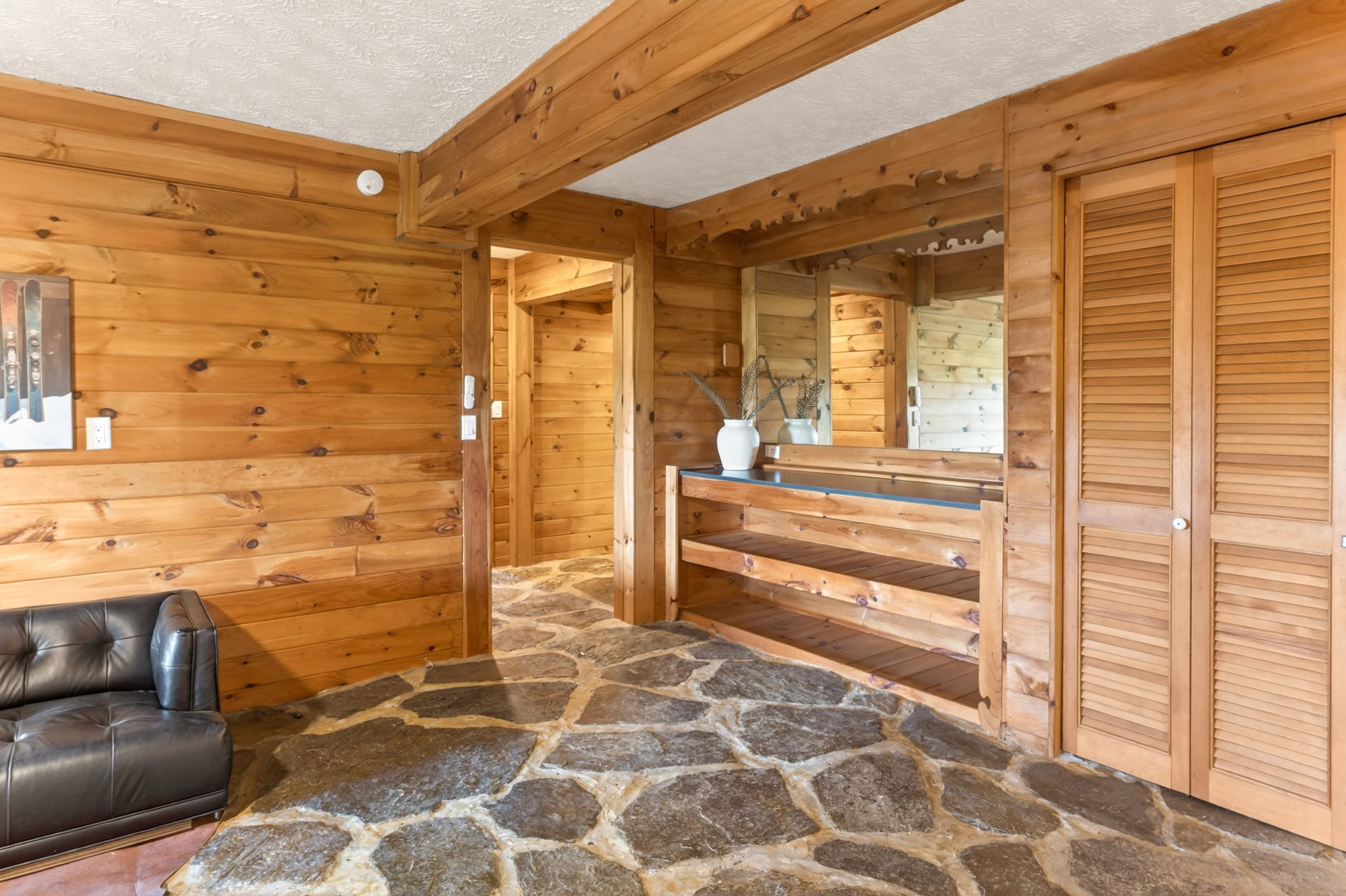 Wood-paneled hallway with stone flooring