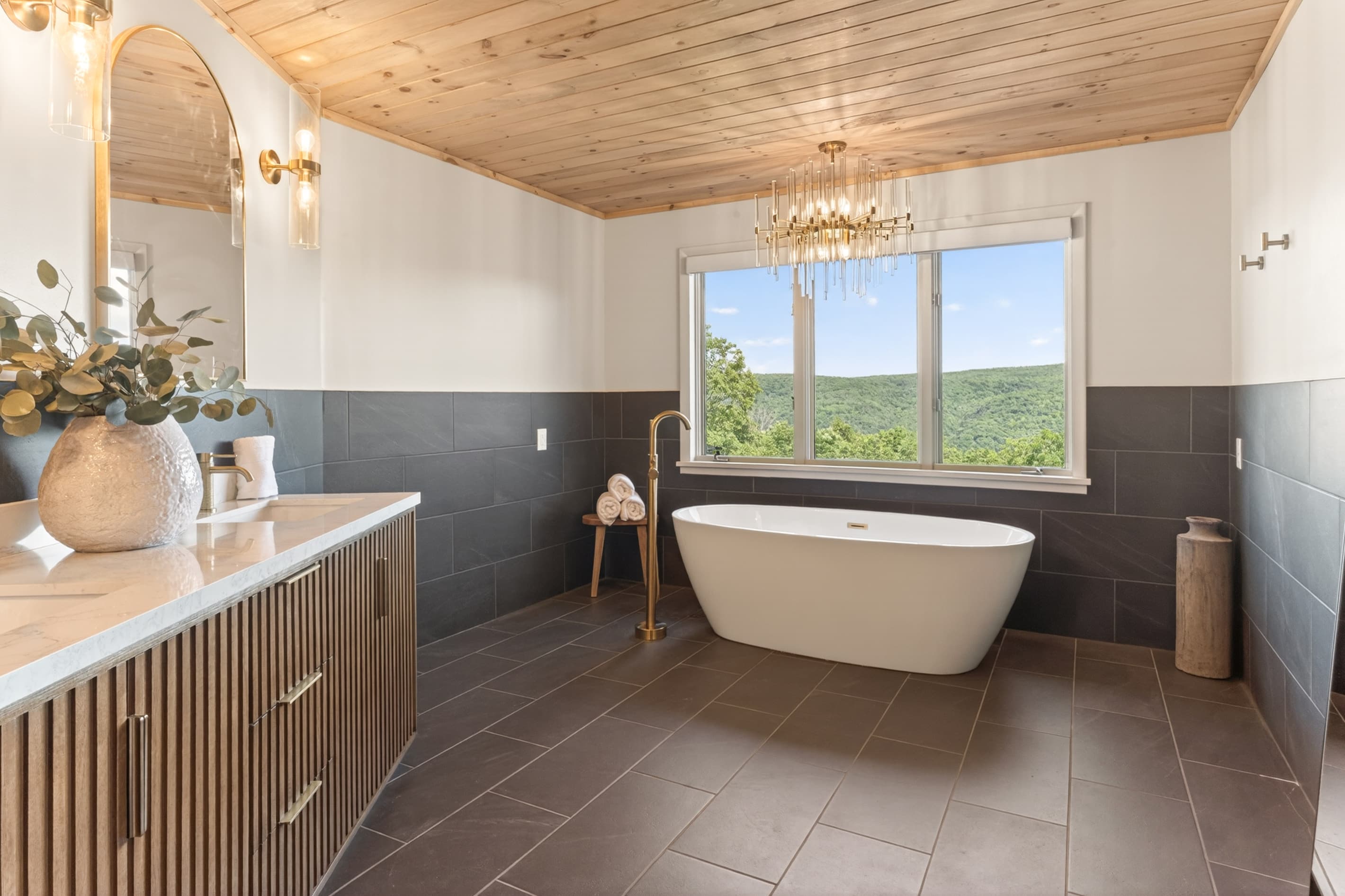 Bathroom with bathtub and black tiles with a view