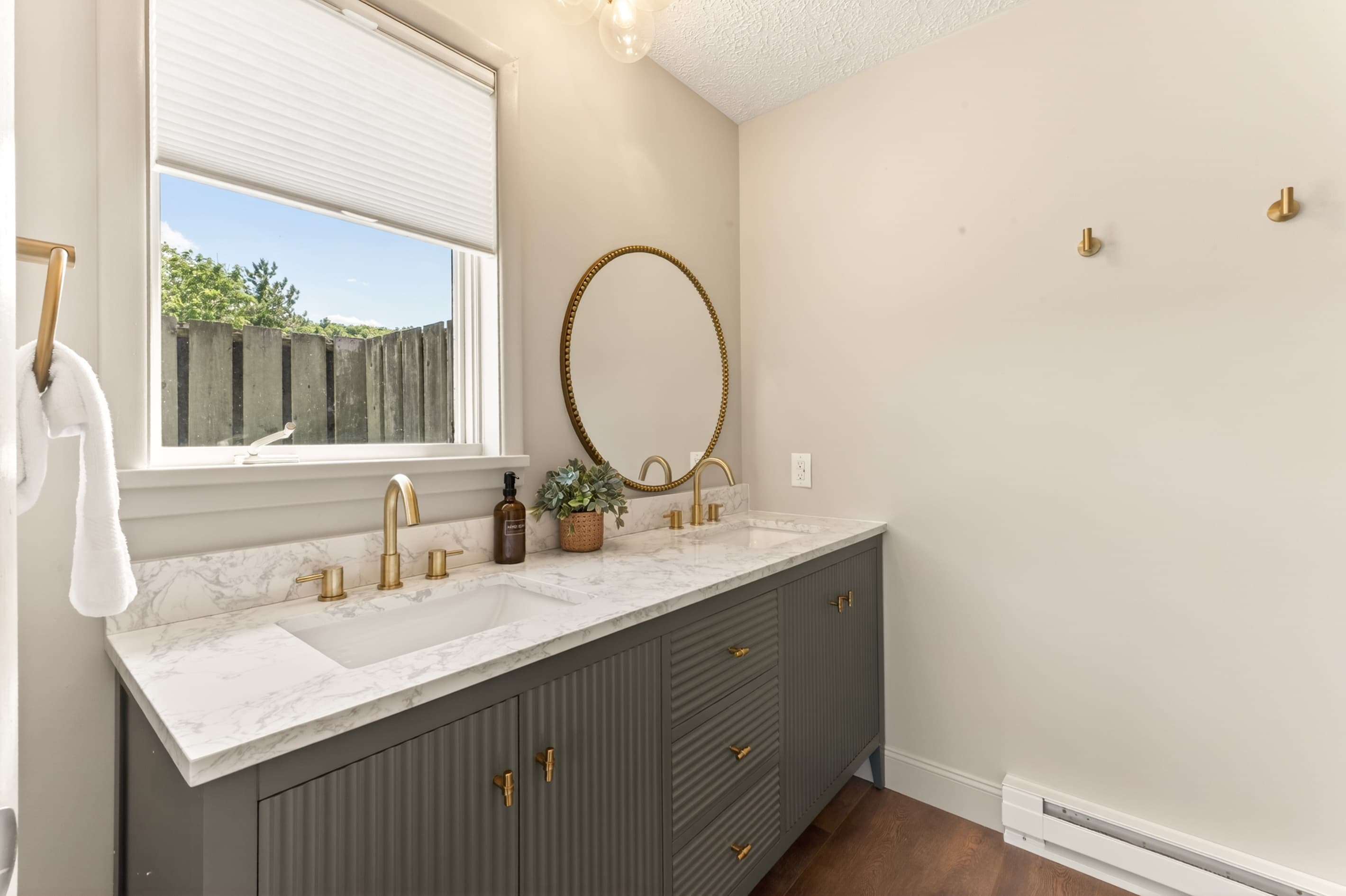Gray vanity beneath a round mirror