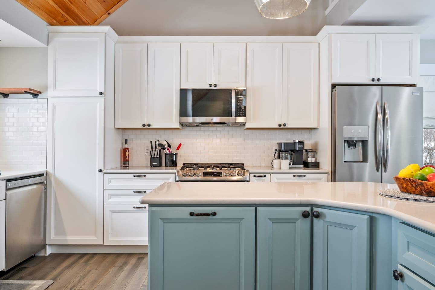 Kitchen with white and teal cabinetry and island