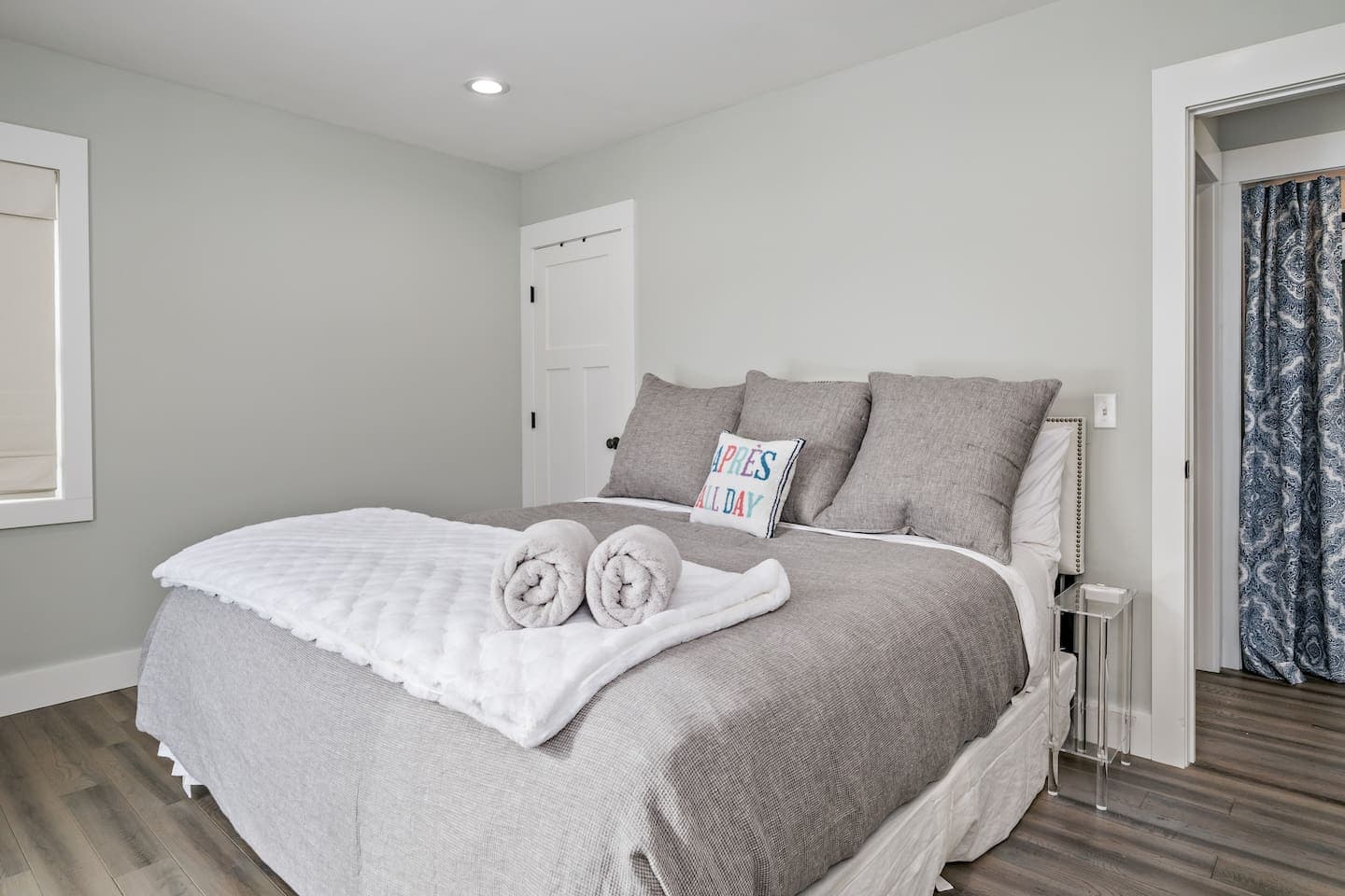 Bedroom with gray bedding and folded towels