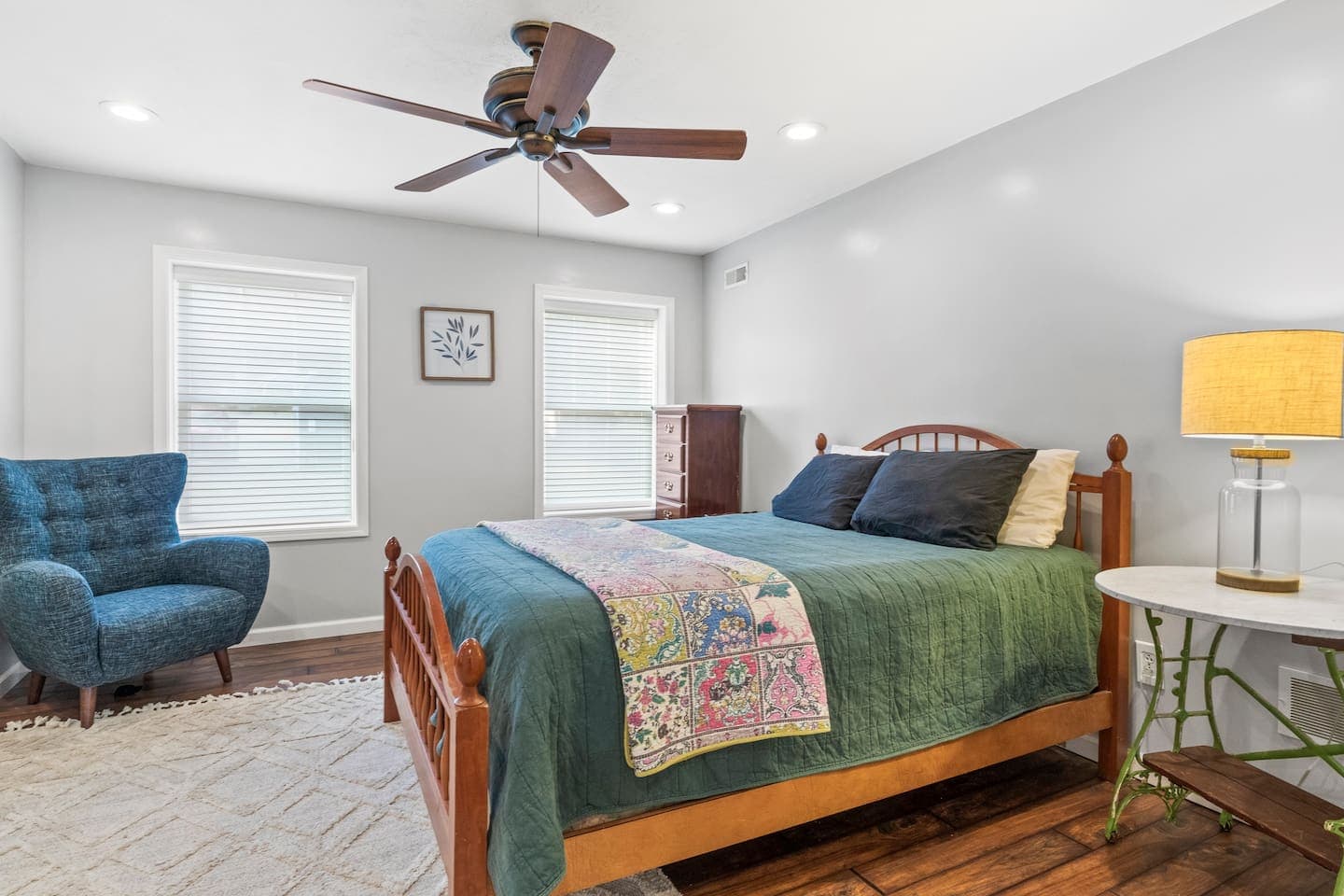 Bedroom with green bedding and armchair