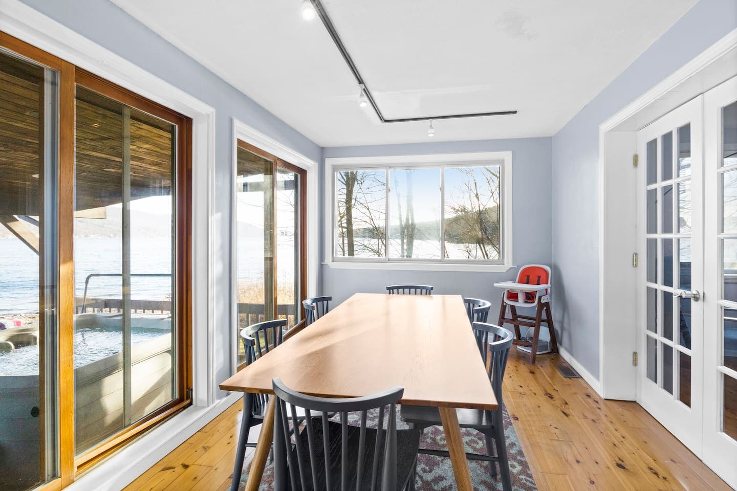 Long dining table beside large windows