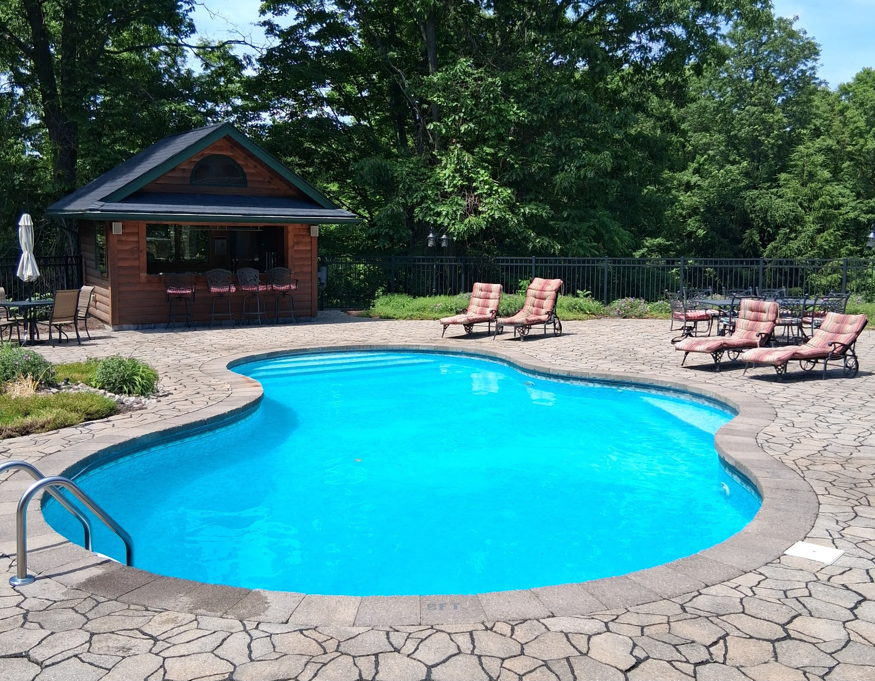 Curved pool surrounded by stone decking