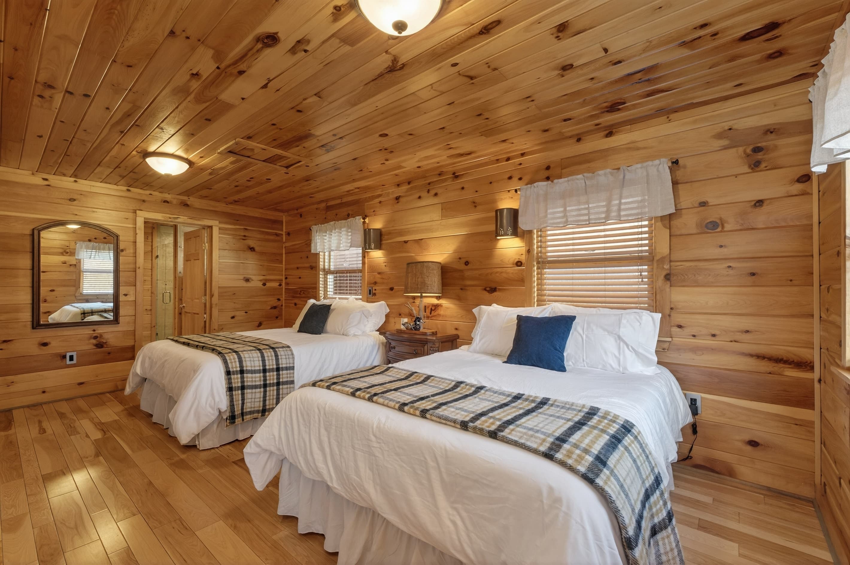 Bedroom with wooden walls and windows