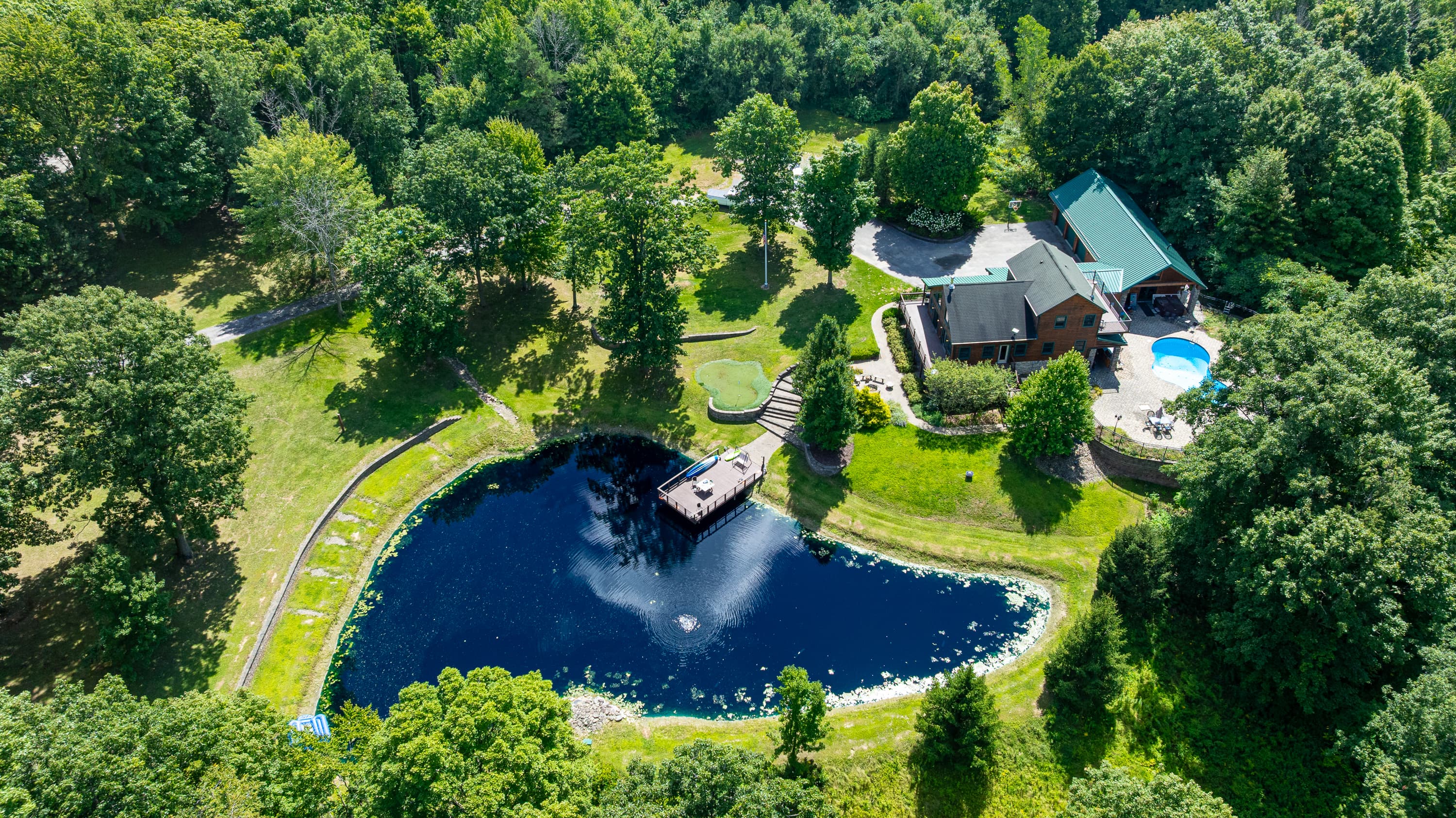 Pond surrounded by lawn and trees