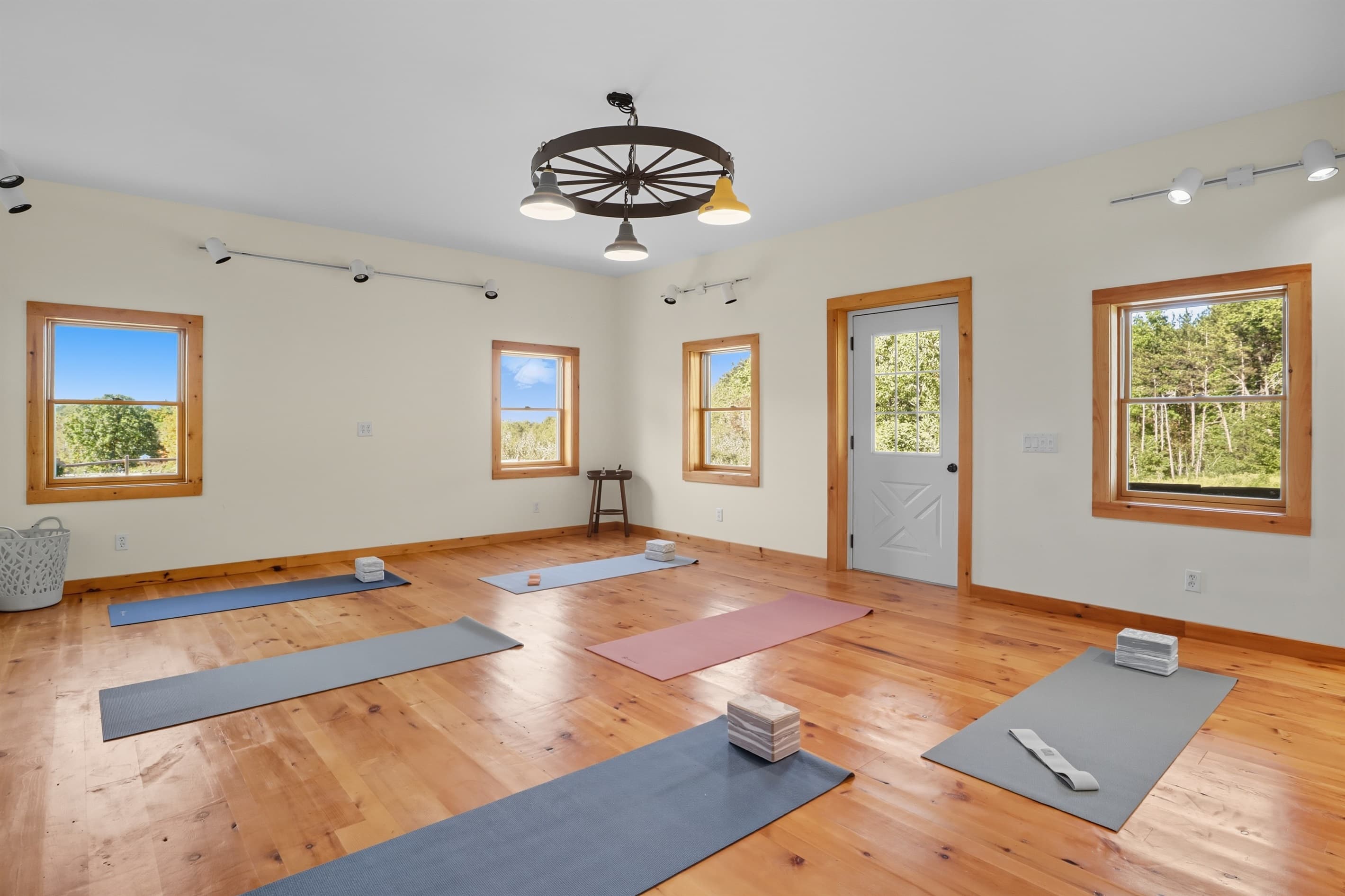Open room with hardwood floors and windows used as a yoga room