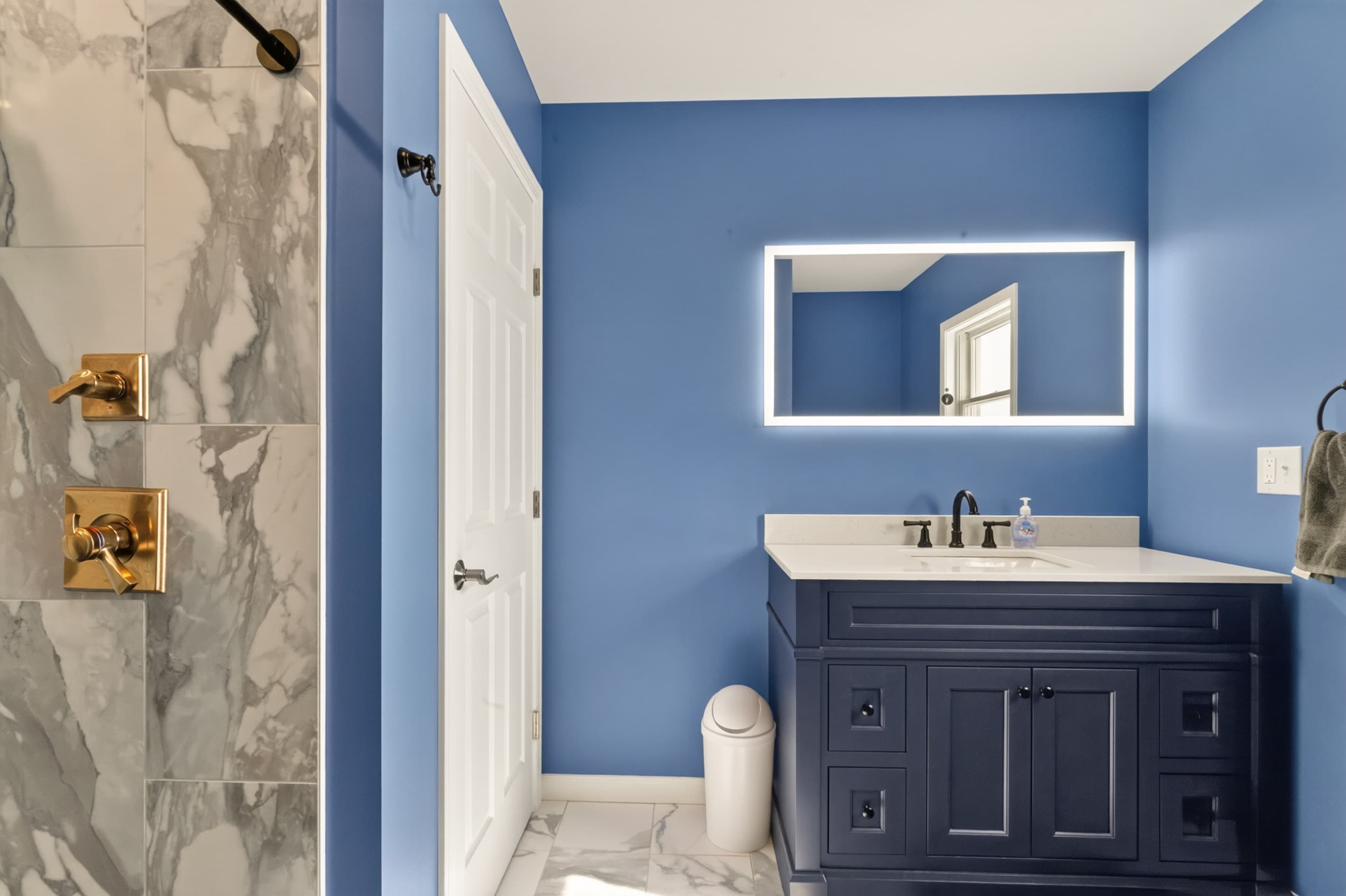Blue bathroom with vanity and wall mirror