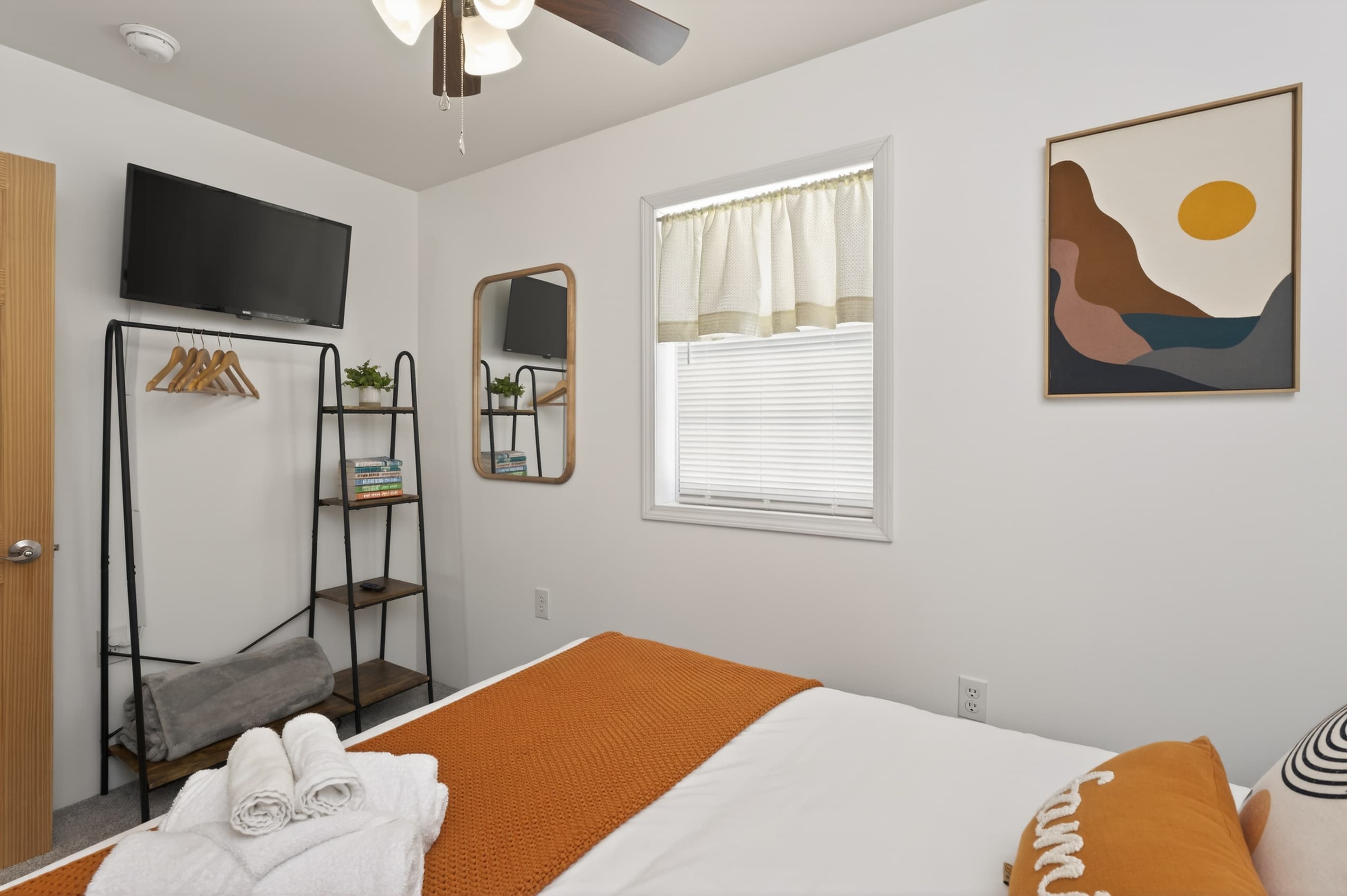 Wall-mounted television opposite the bed