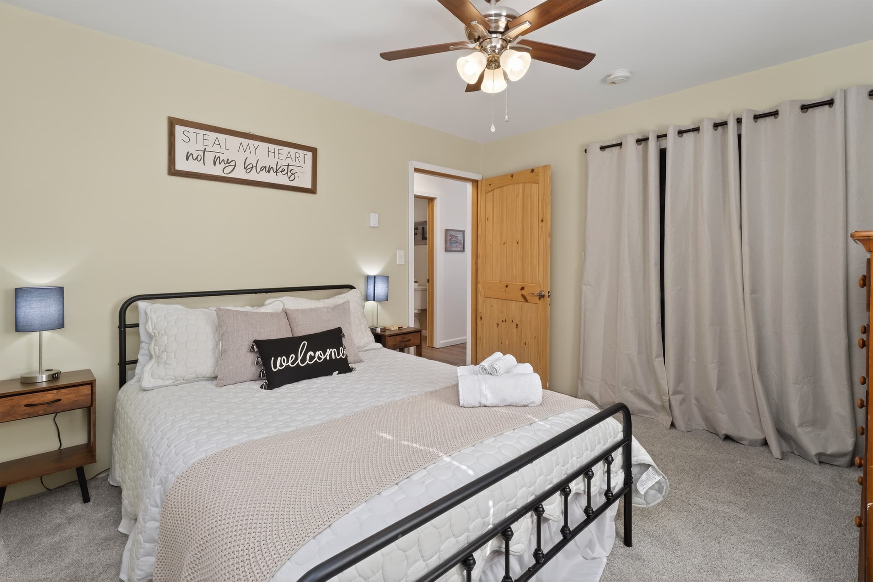 Metal-frame bed beside floor-length curtains