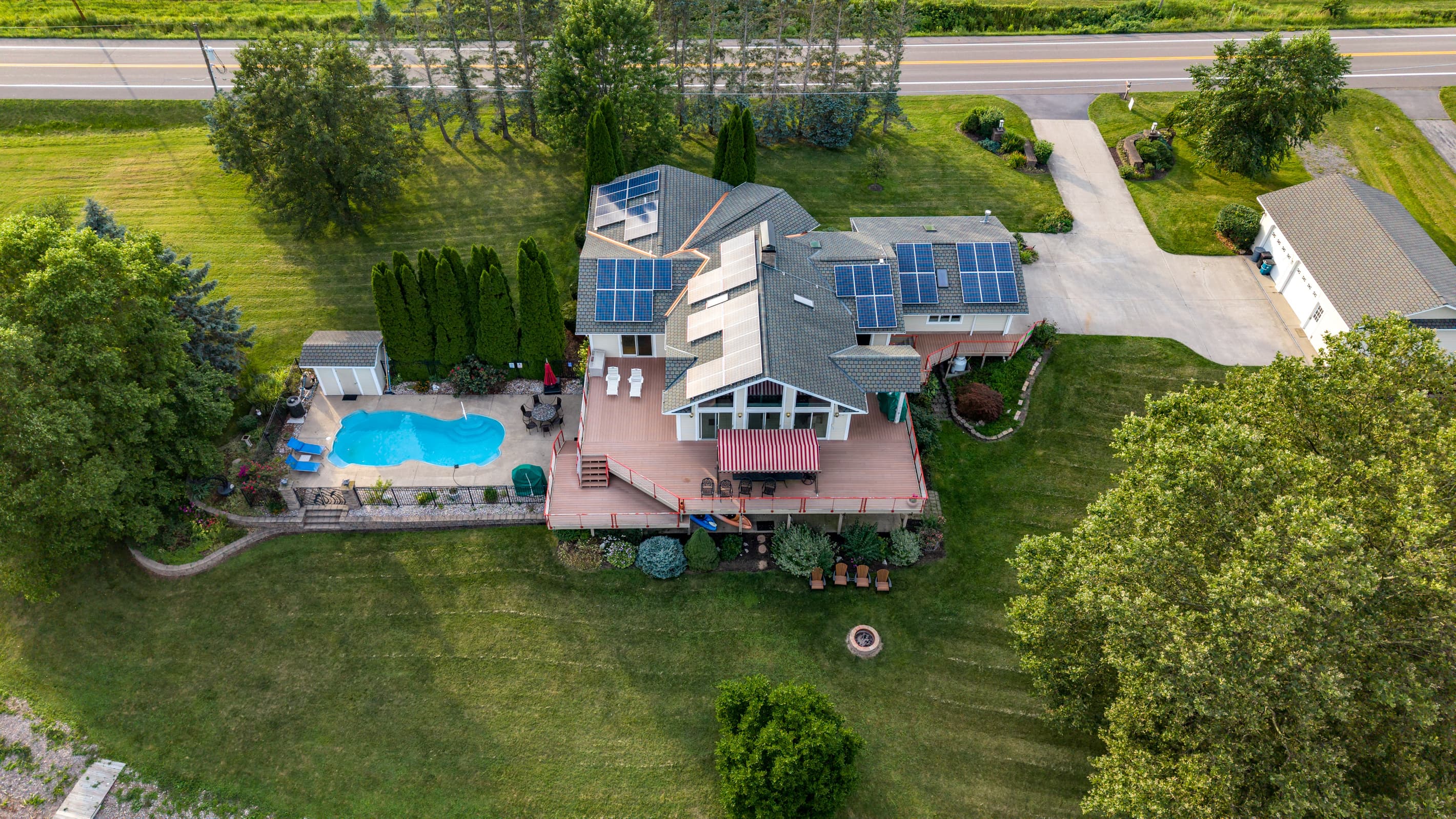 Property overview showing pool, decks, and lawn