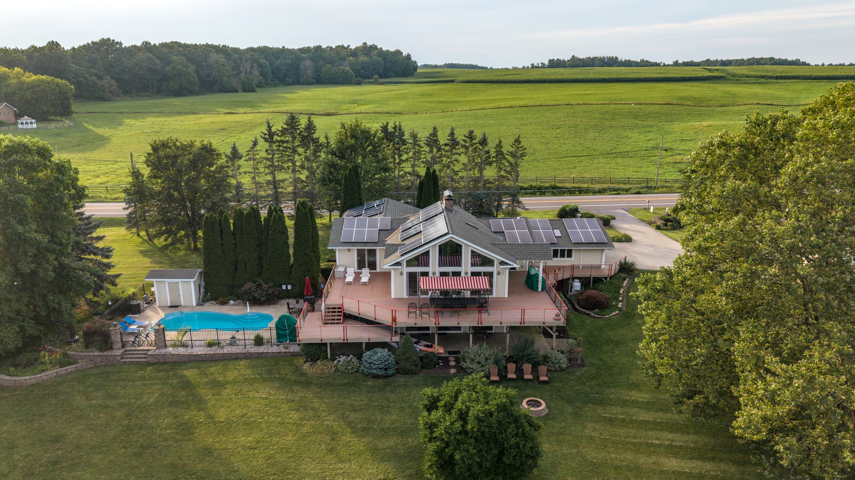 Rear lawn, swimming pool, and wraparound deck