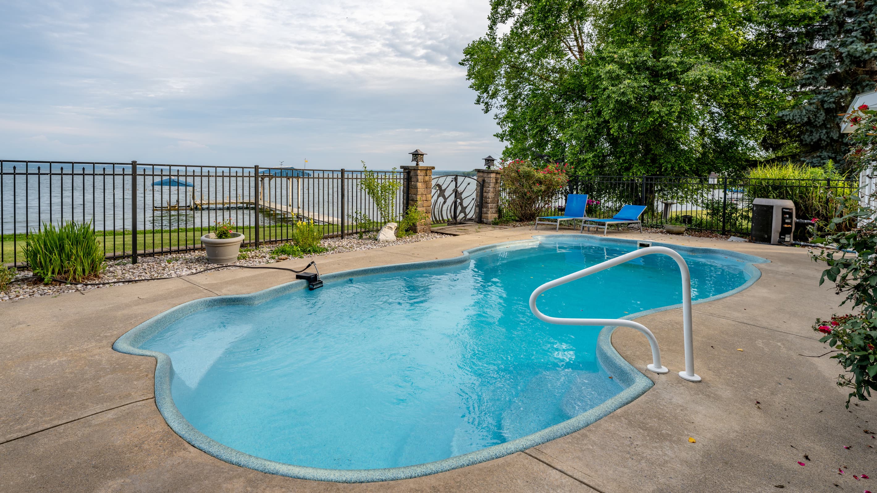 Curved swimming pool with water views beyond