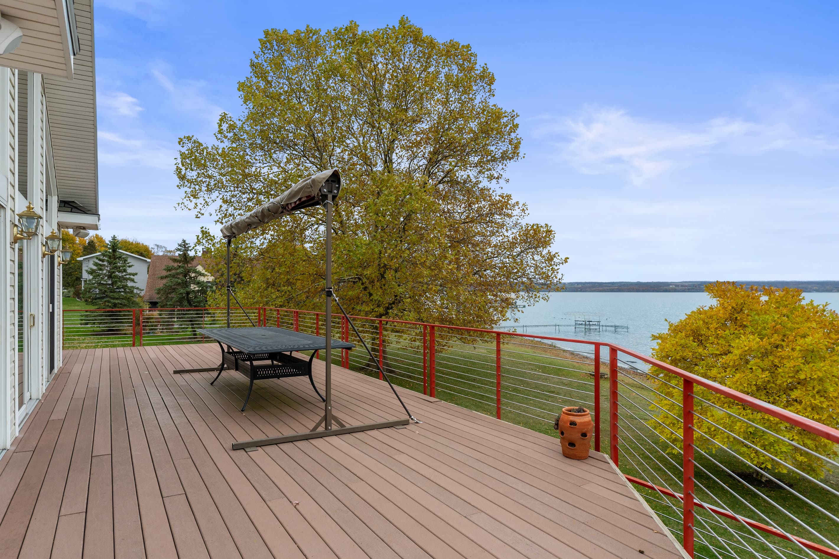 Red fence surrounding wooden deck overlooking the lake