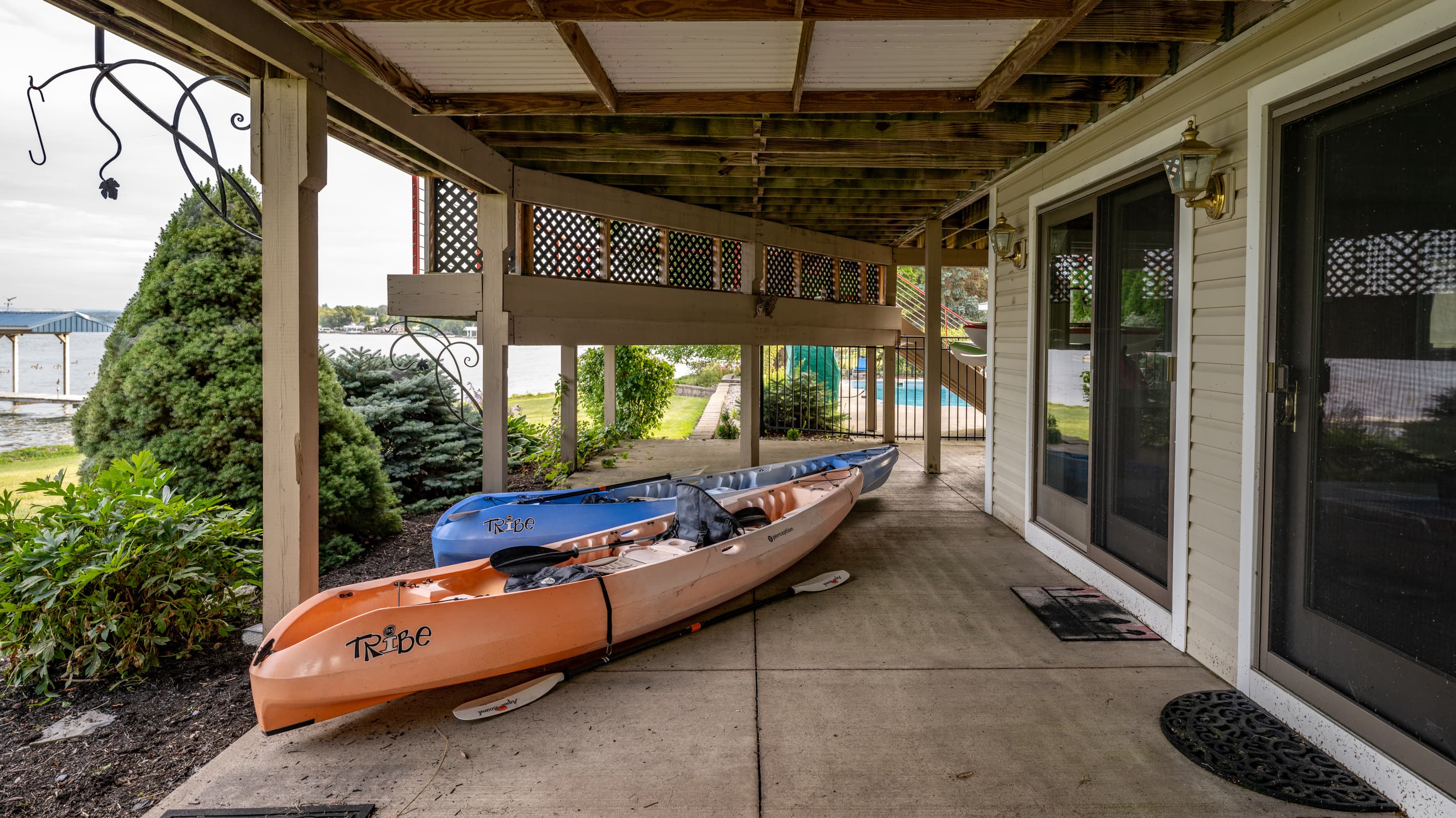 Two kayaks stored along the covered patio