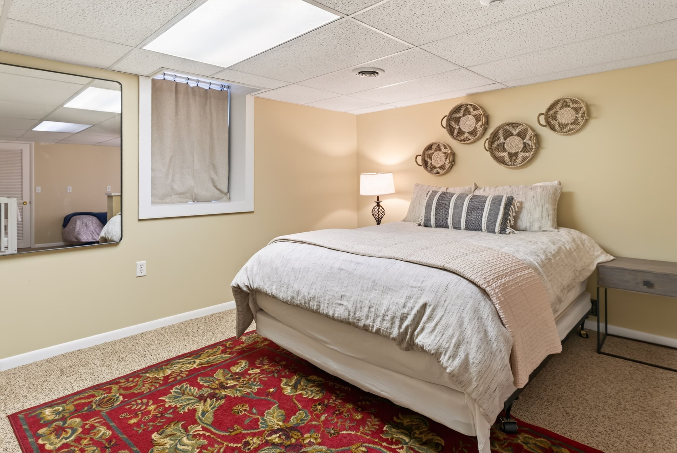Bedroom with queen bed and patterned rug