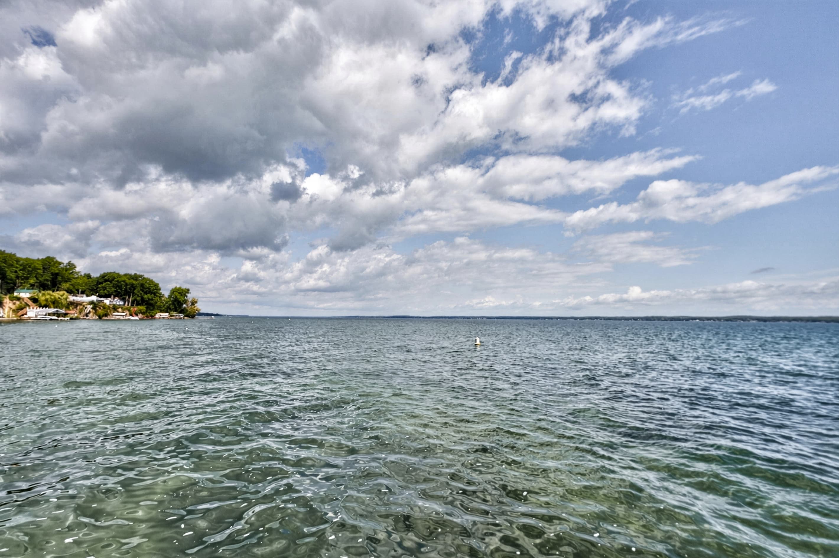 Open water beneath partly cloudy skies
