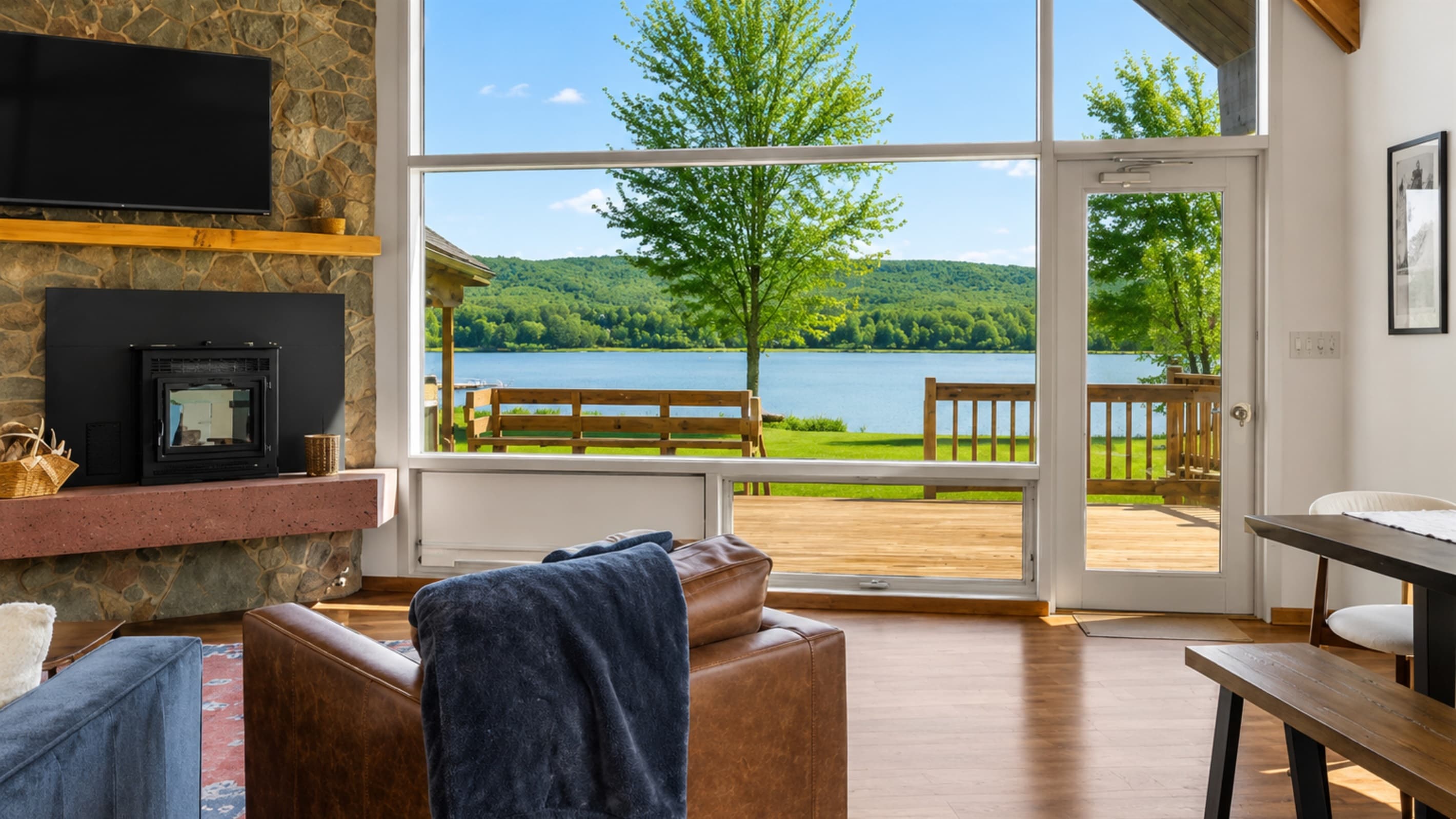 Stone fireplace beside lake-facing windows