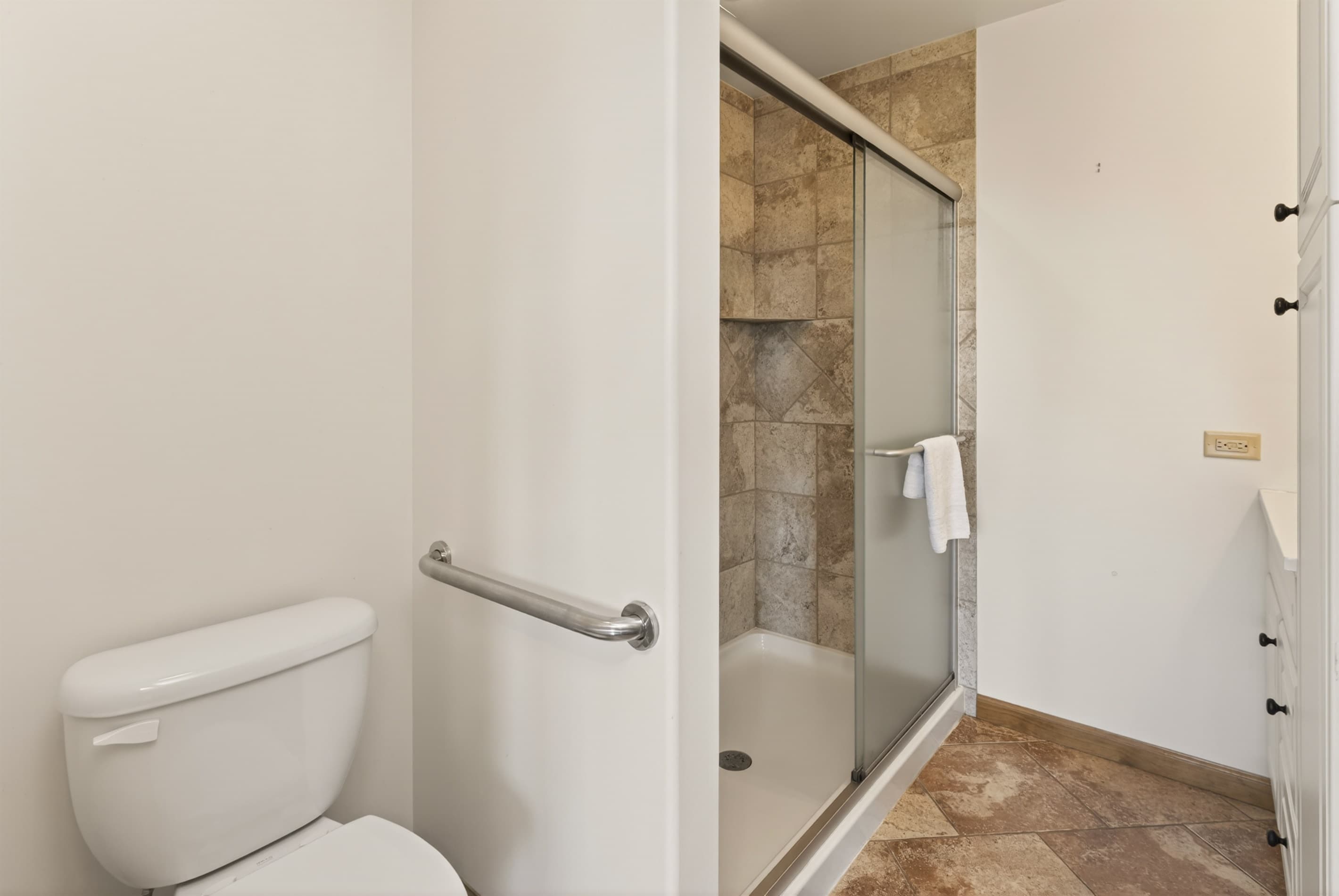 Bathroom with glass-enclosed shower and toilet