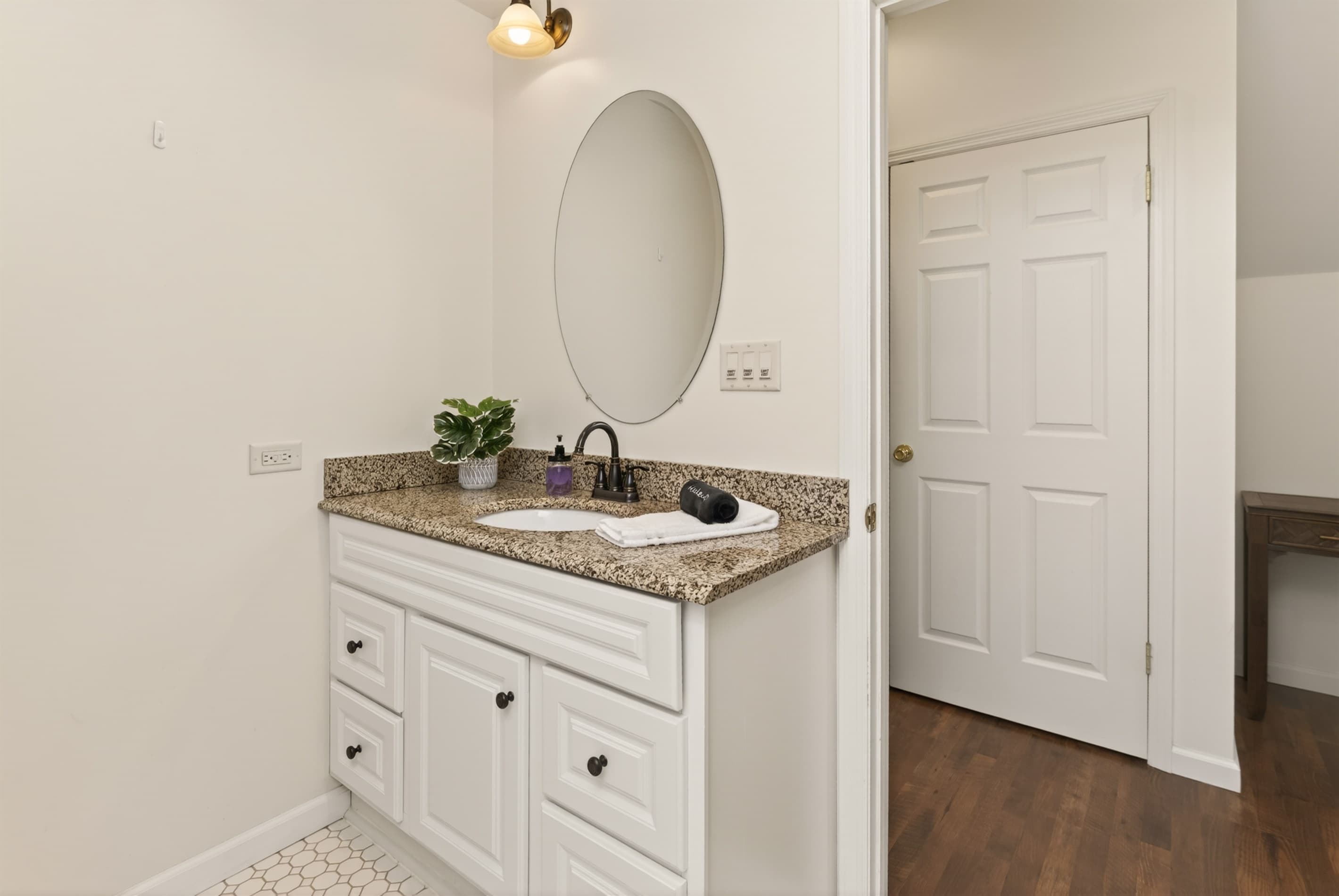 White dresser with oval wall mirror