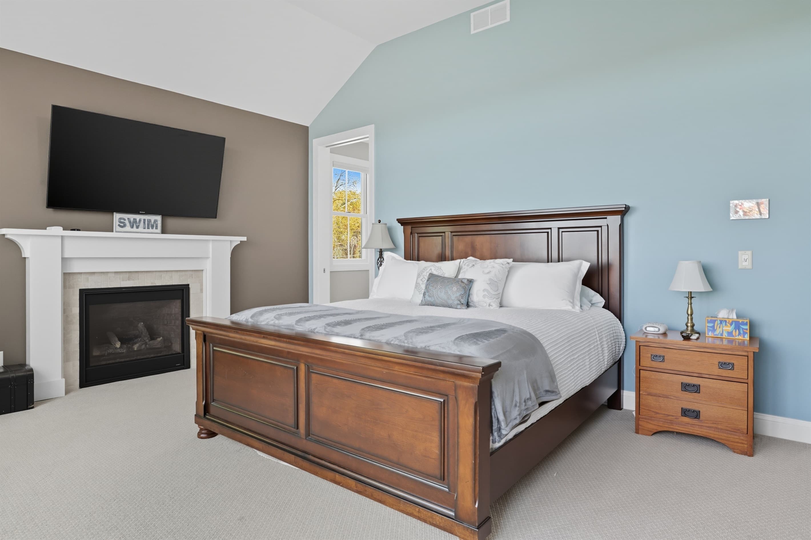 Bedroom with fireplace and wall-mounted television