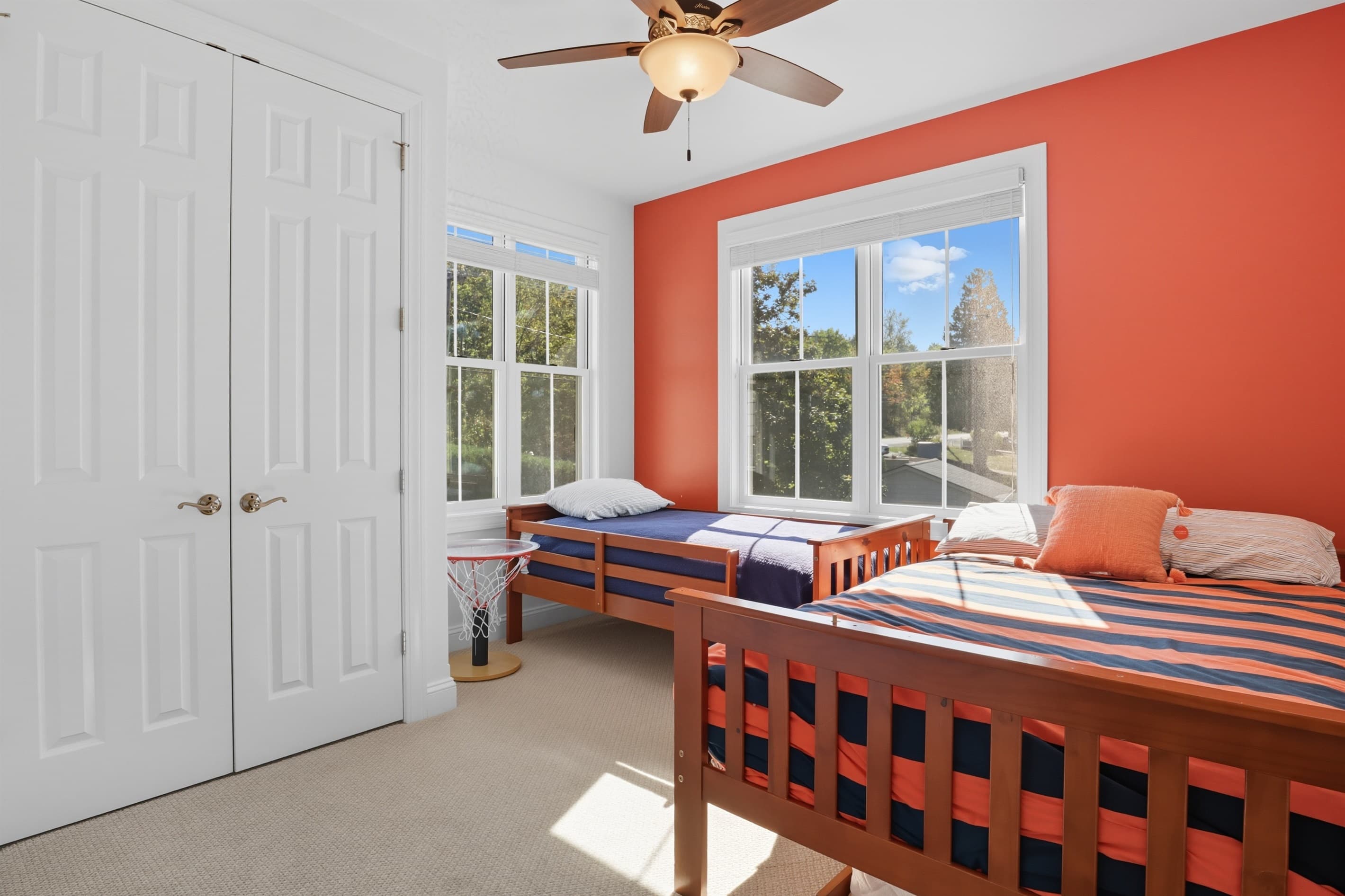 Two beds against red orange accent wall
