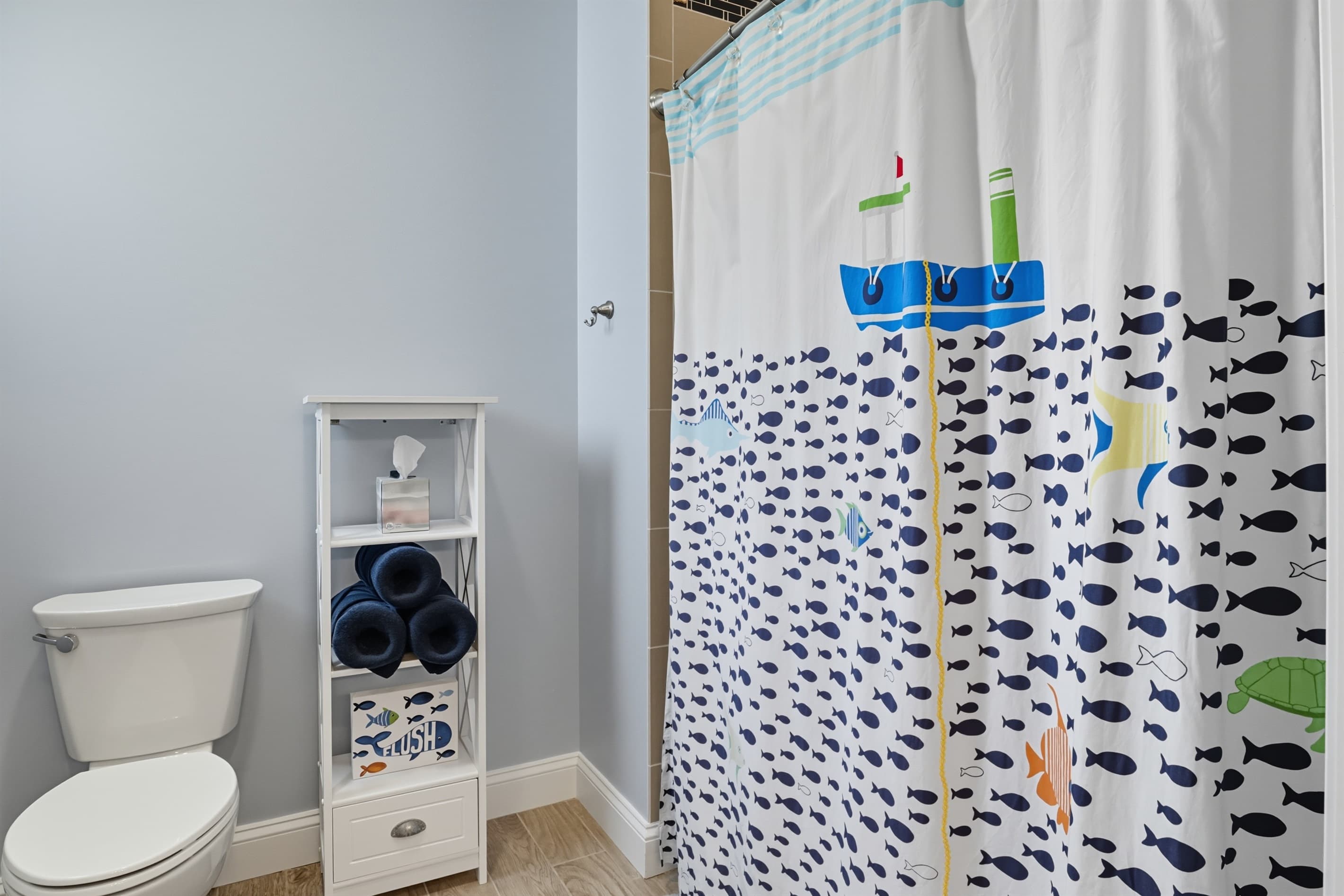 Shower with fish patterned curtain