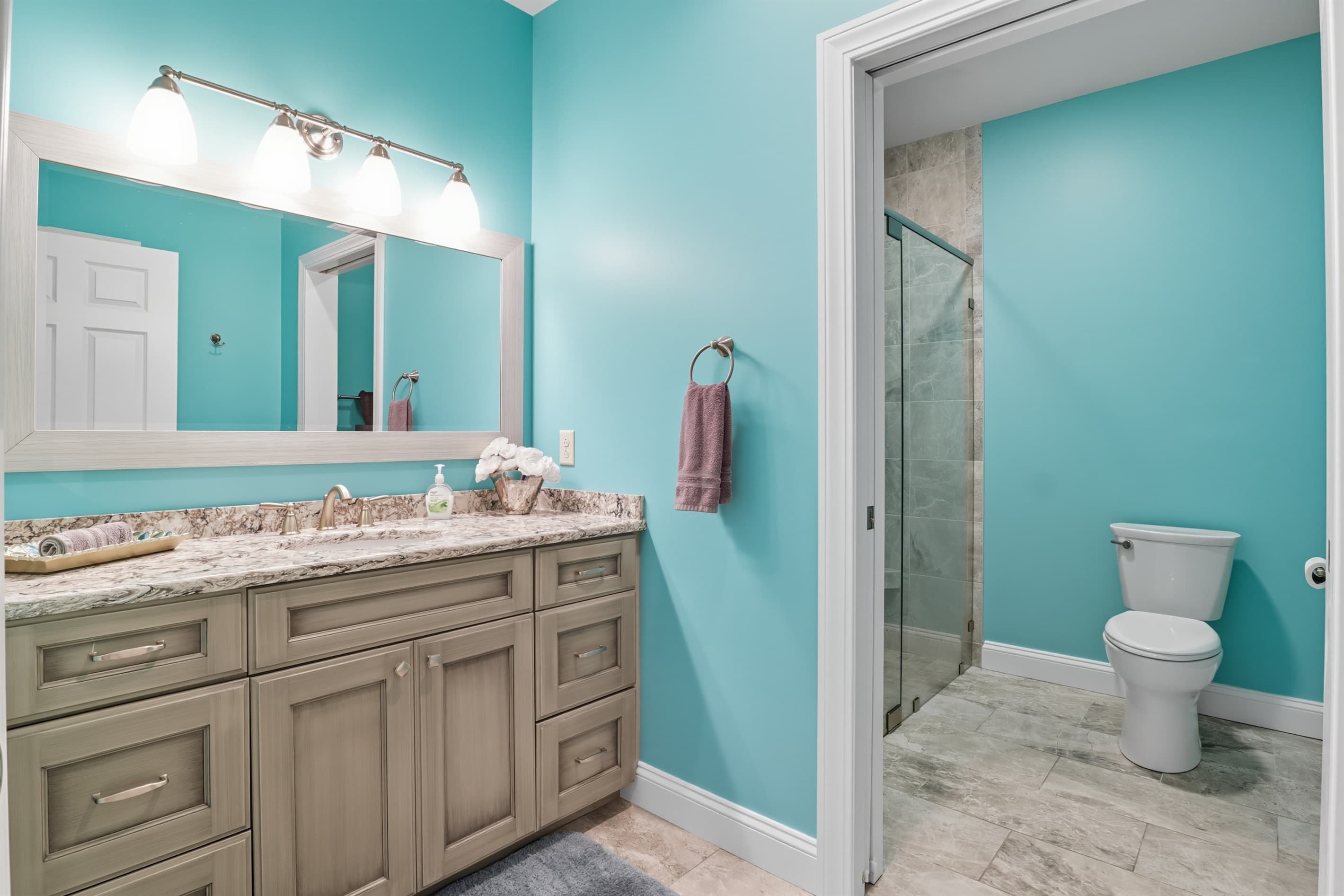Turquoise bathroom with vanity and toilet