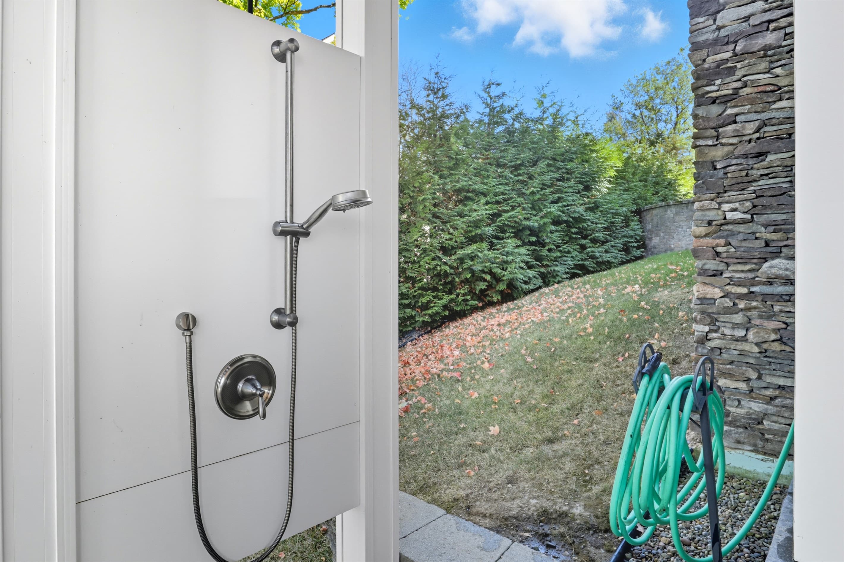 Outdoor shower beside hose storage