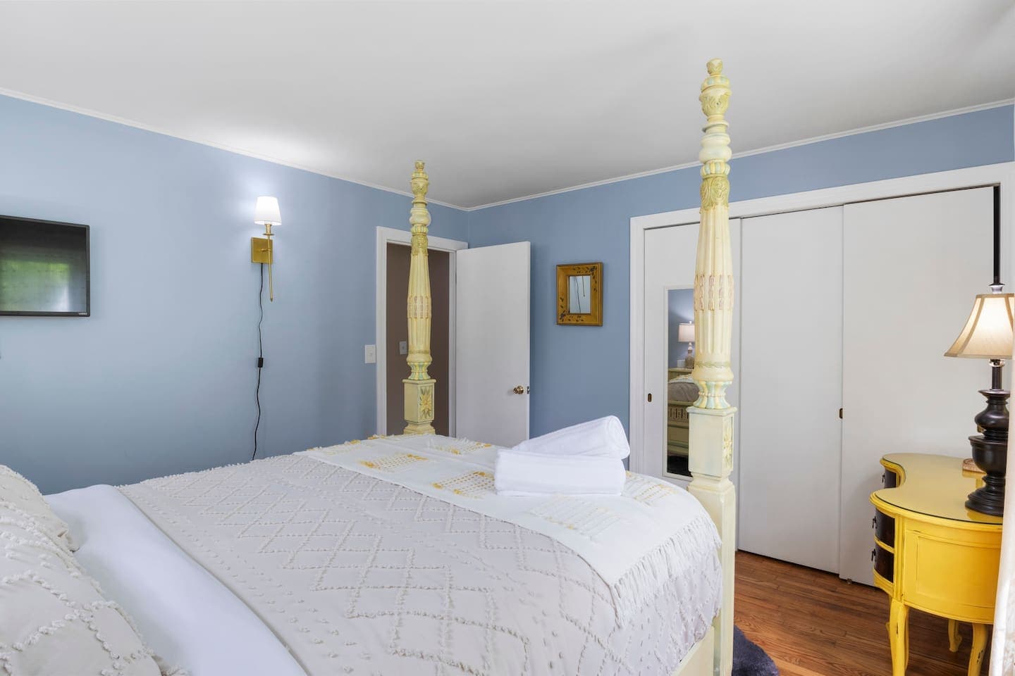 Bed beside mirrored closet doors