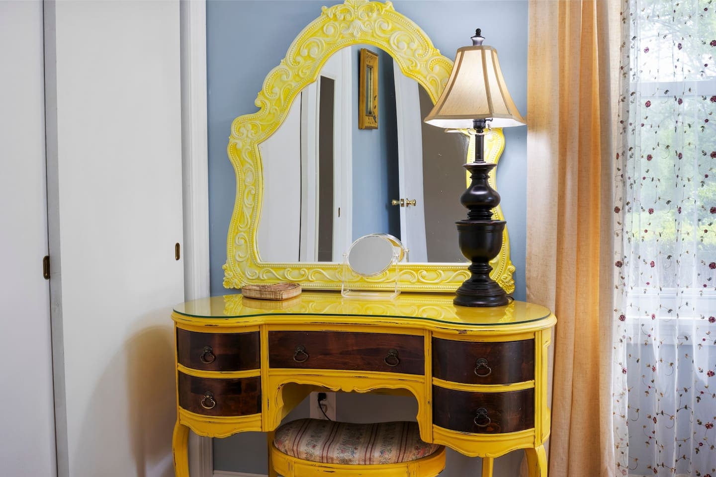 Yellow vanity with oval mirror