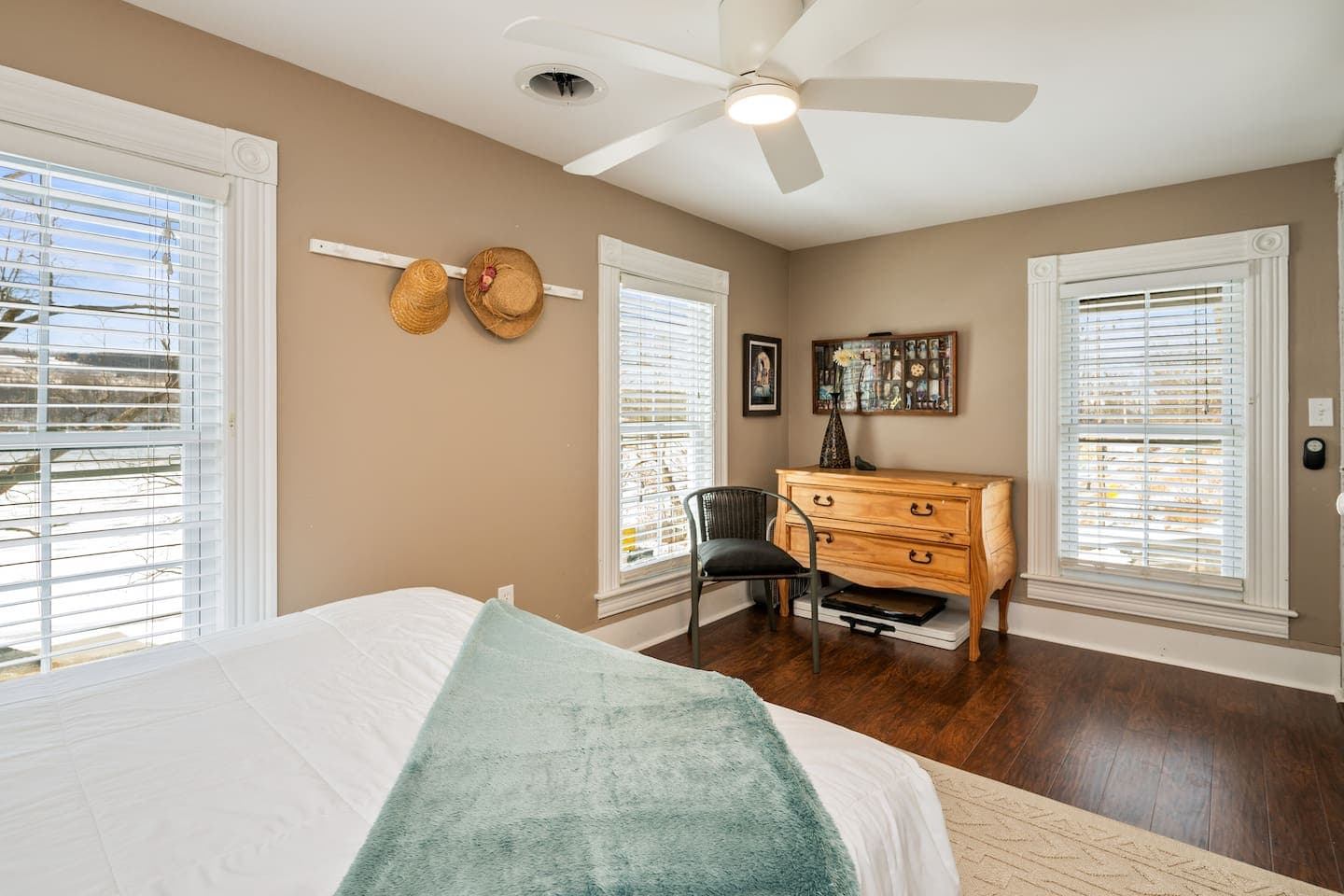 Wooden dresser between two windows