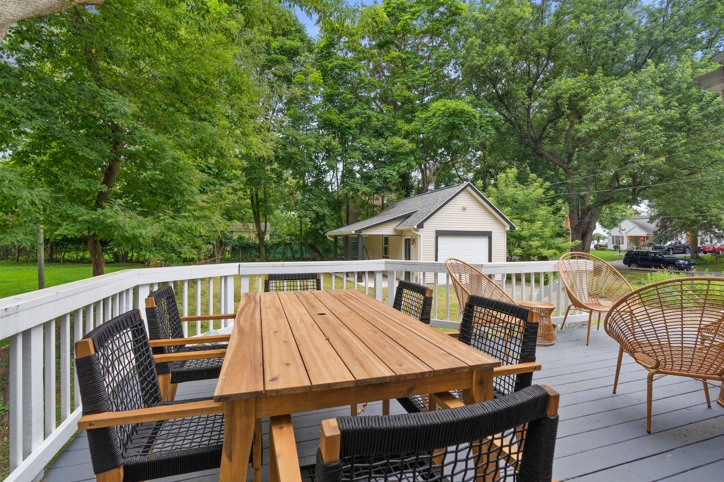 Dining table beside the deck railing overlooking the backyard