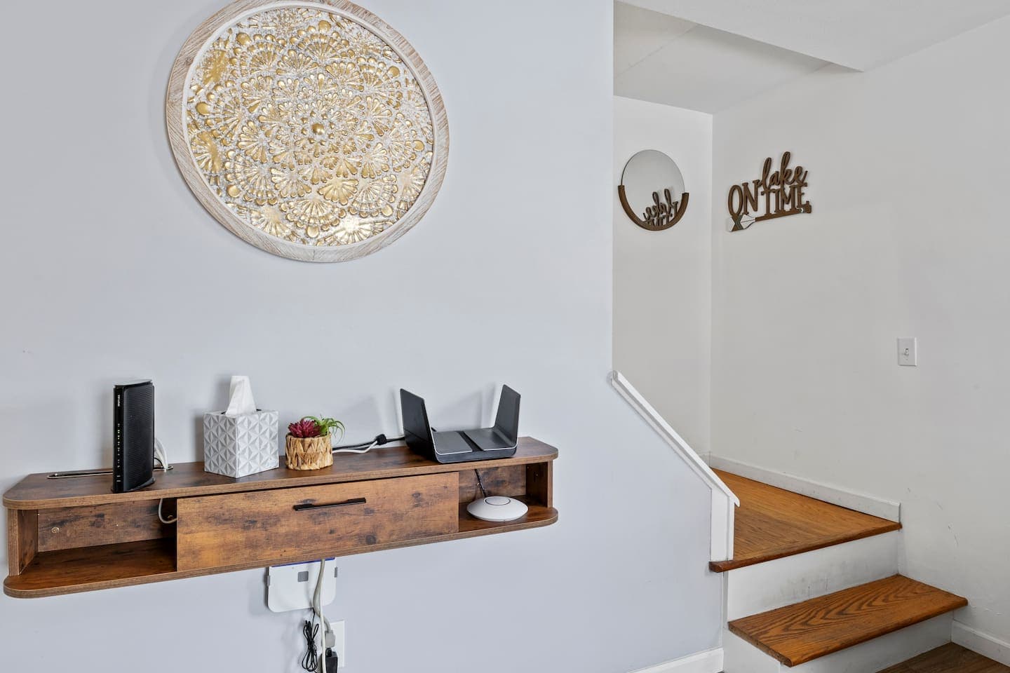Stairway with wooden handrail and wall shelf